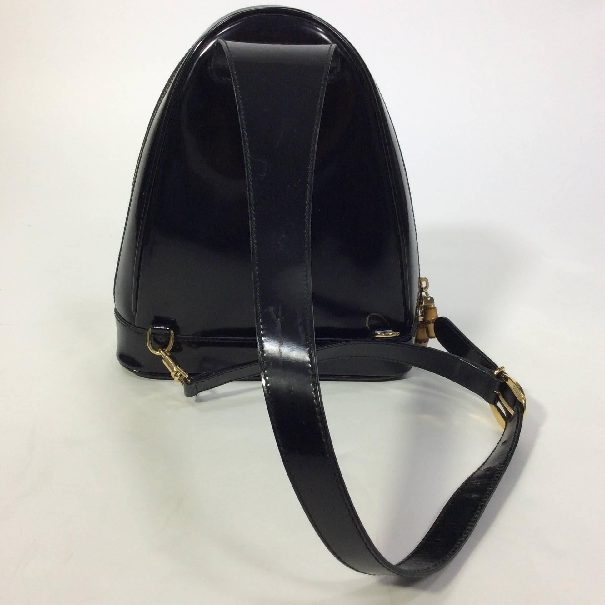 Gucci Black High Polished Leather Sling Bag from the 80's in amazing overall condition. The bag is leather lined with bamboo zipper closures and includes the original dustbag. The sling shoulder strap is 32" in length and adjustable to either