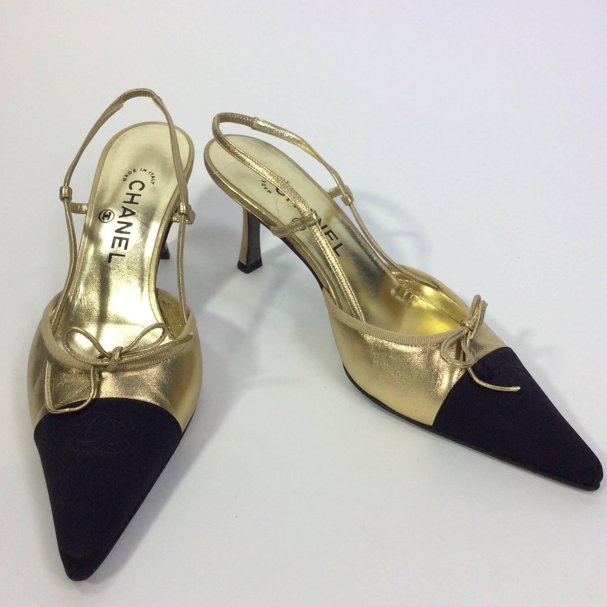 Gold and Black Slingback with Tie Detail
3 inch heel
3 inch sole width
Chanel logo stitching on black toe
Gold tie on toe
Elastic slingback style
Size 40 (equates to a US 9)
Leather and silk