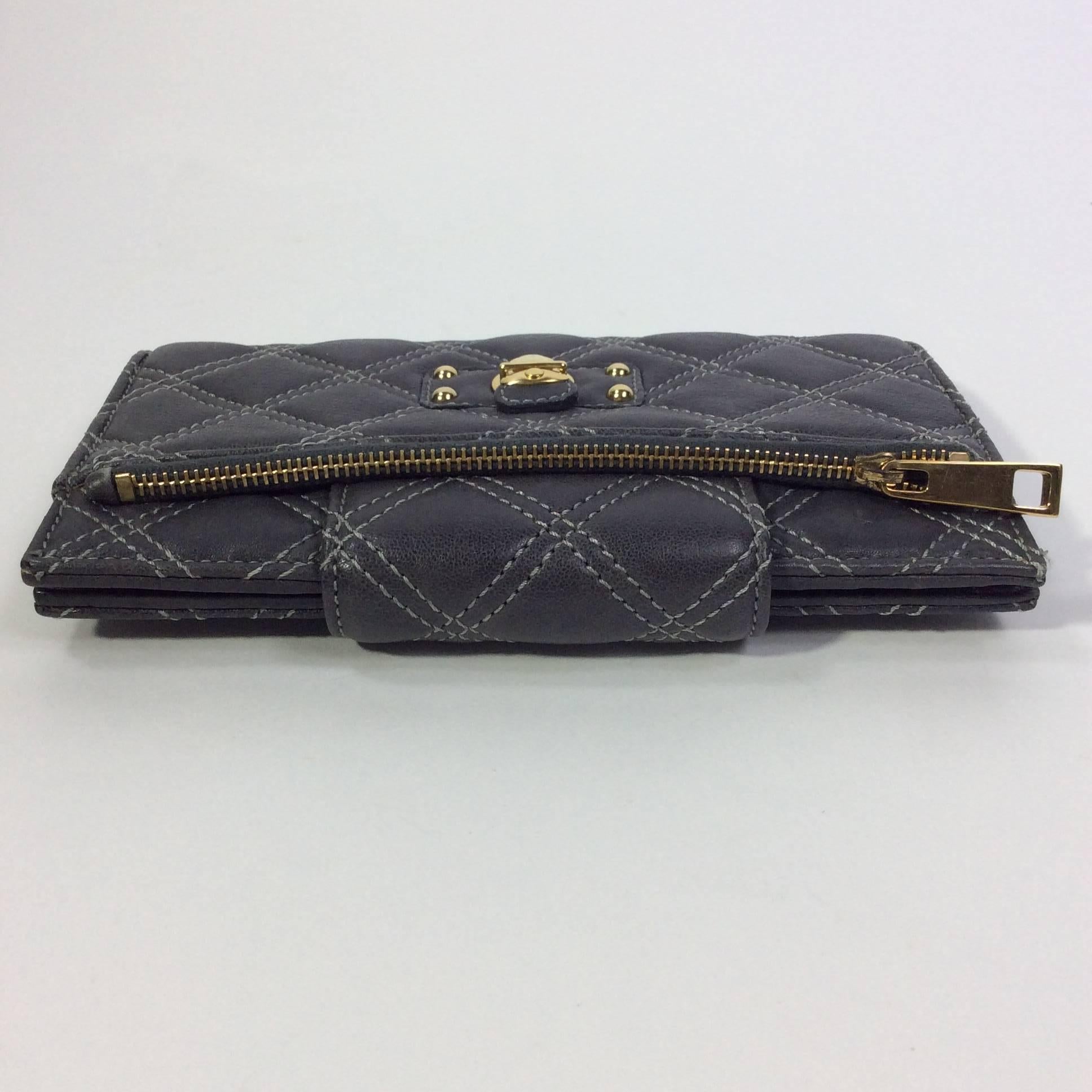 Grey Quilted Leather Wallet
4.5 inches tall, 7.5 inches wide, and 0.75 inches deep
Includes front zipper pocket and decorative gold clasp
Back pocket snaps shut
14 available card slots with one windowed slot
Grey leather with light grey