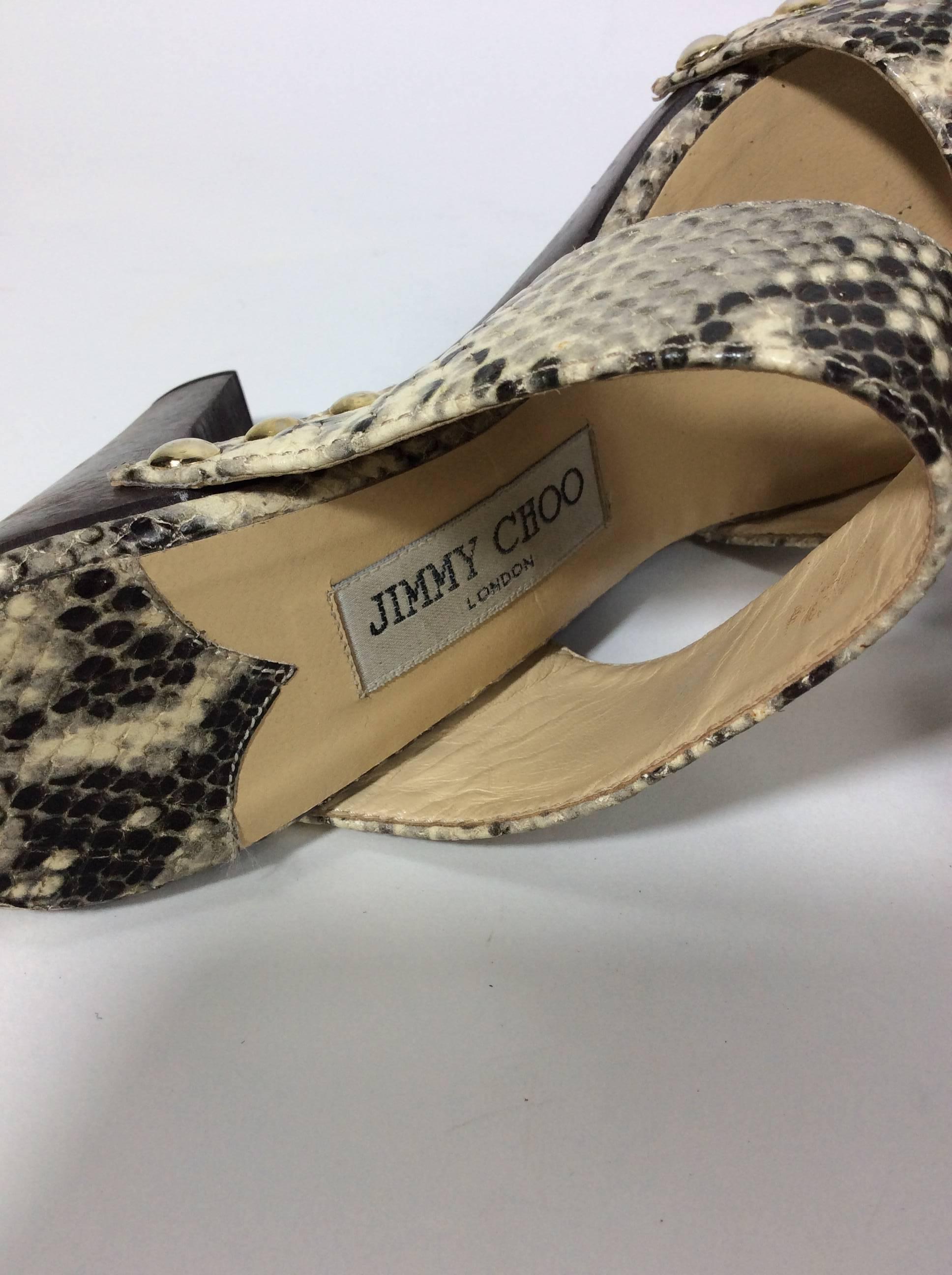 Grey and Brown Snakeskin Slides
4 inch heel with a 1 inch platform
2.75 inch sole width
Snakeskin straps with silver rivets on each side 
Brown wooden sole and heel
Tan leather lining
Size 37 (equates to a US 7)