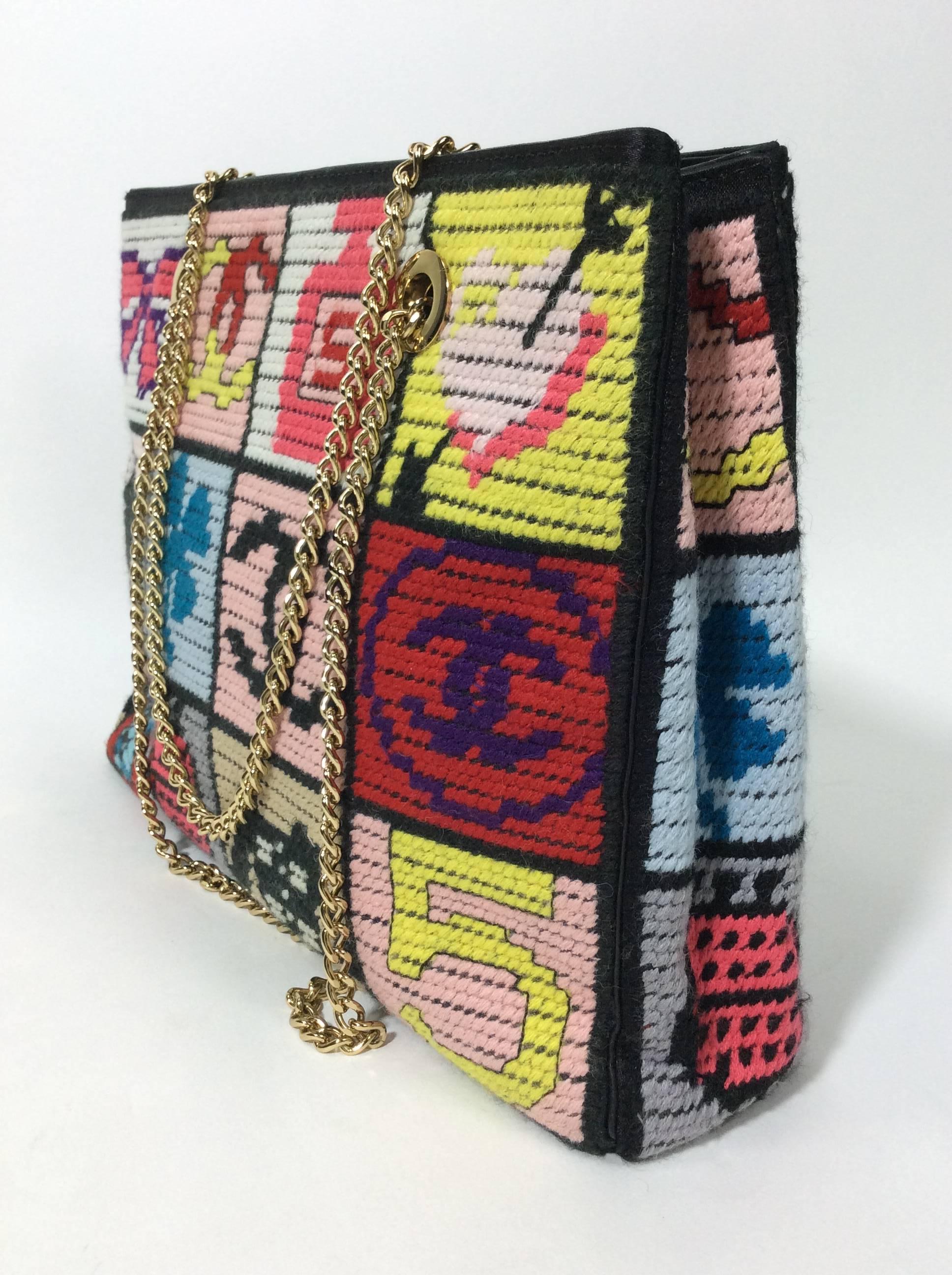 Precious Symbols Embroidered Patchwork Top Handle Bag
Limited Edition bag from 2002
8.5 inches tall, 11 inches wide, and 3 inches deep
8.5 inch strap drop
Embroidered patchwork symbols in pink, red, yellow, teal blue, and purple with black
