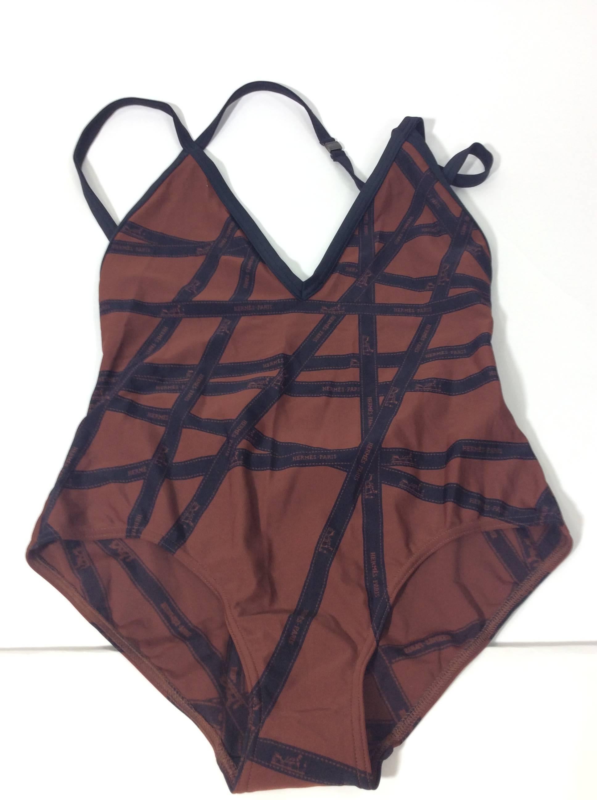 Ribbon Print Brown and Navy Swimsuit
Includes halter and shoulder straps
Open back and v-neck
Ribbon print with Hermes logo
Size 40
80% Polyamide, 20% Elastine