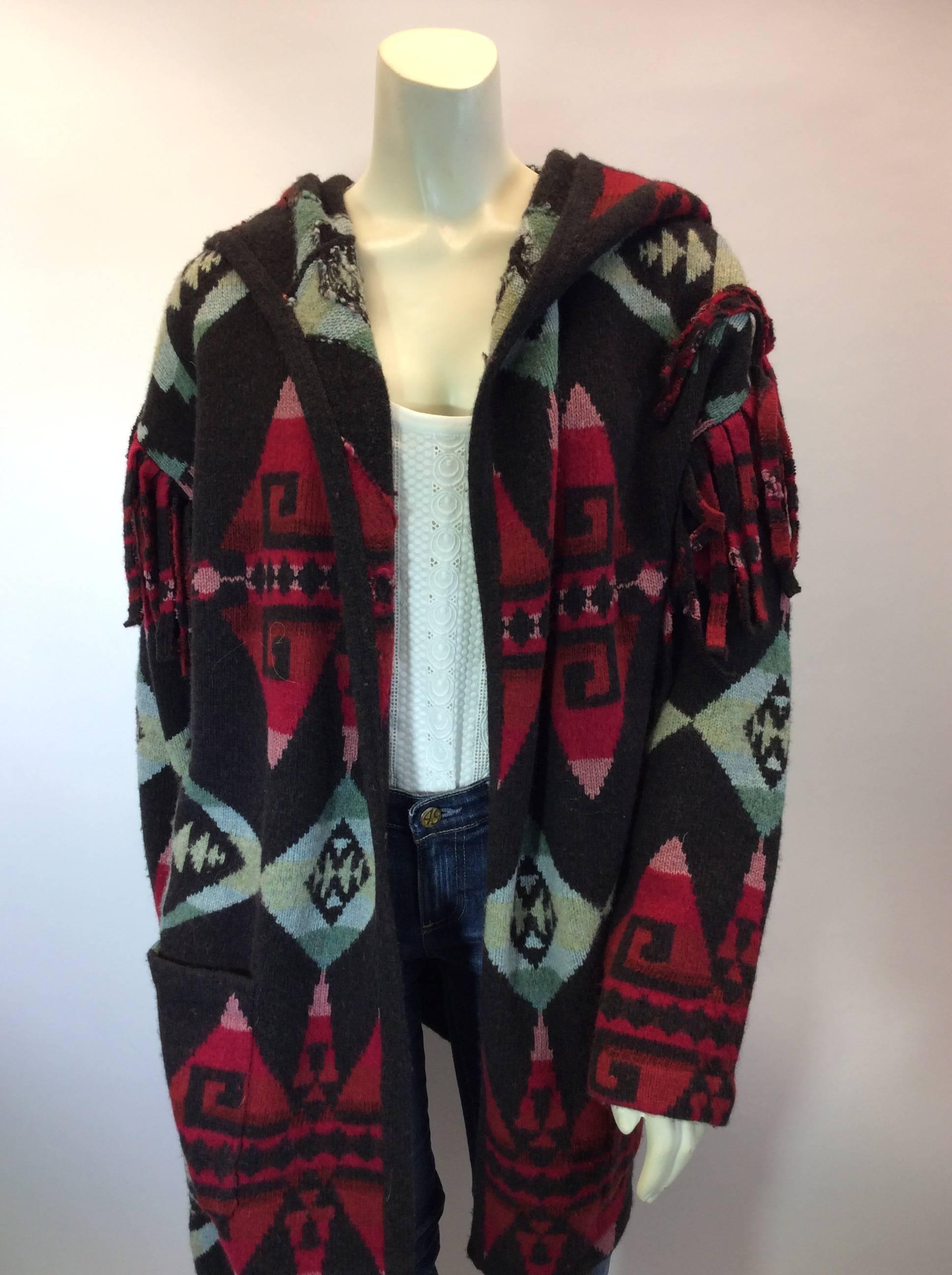 Multicolor Patterned Wrap Sweater with Fringe
Includes fringe around shoulder
Belted waistline
Two hip pockets
Size Small
100% Wool