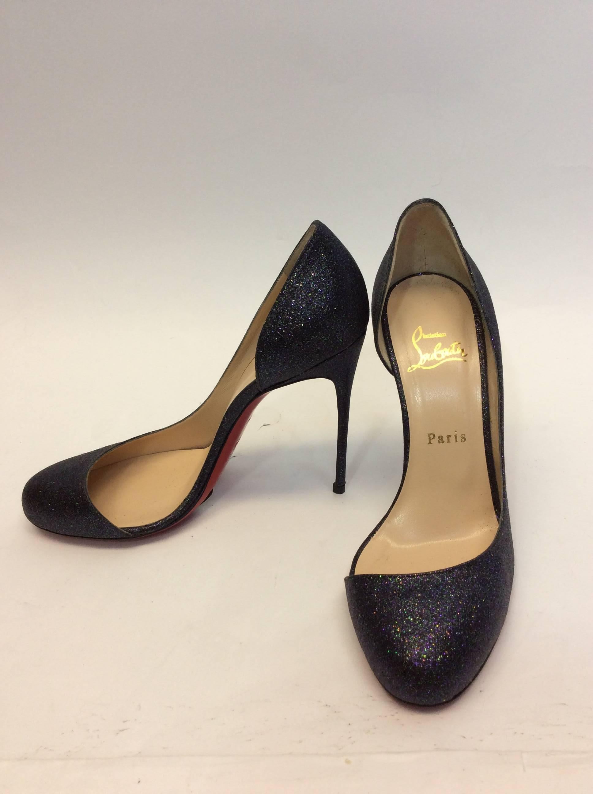 Blue Toned Glitter Pumps
4.5 inch heel
3.5 inch sole width
Red bottoms intact
Multicolored glitter texture
Size 38 (equates to US 7.5)
Textured upper with leather lining