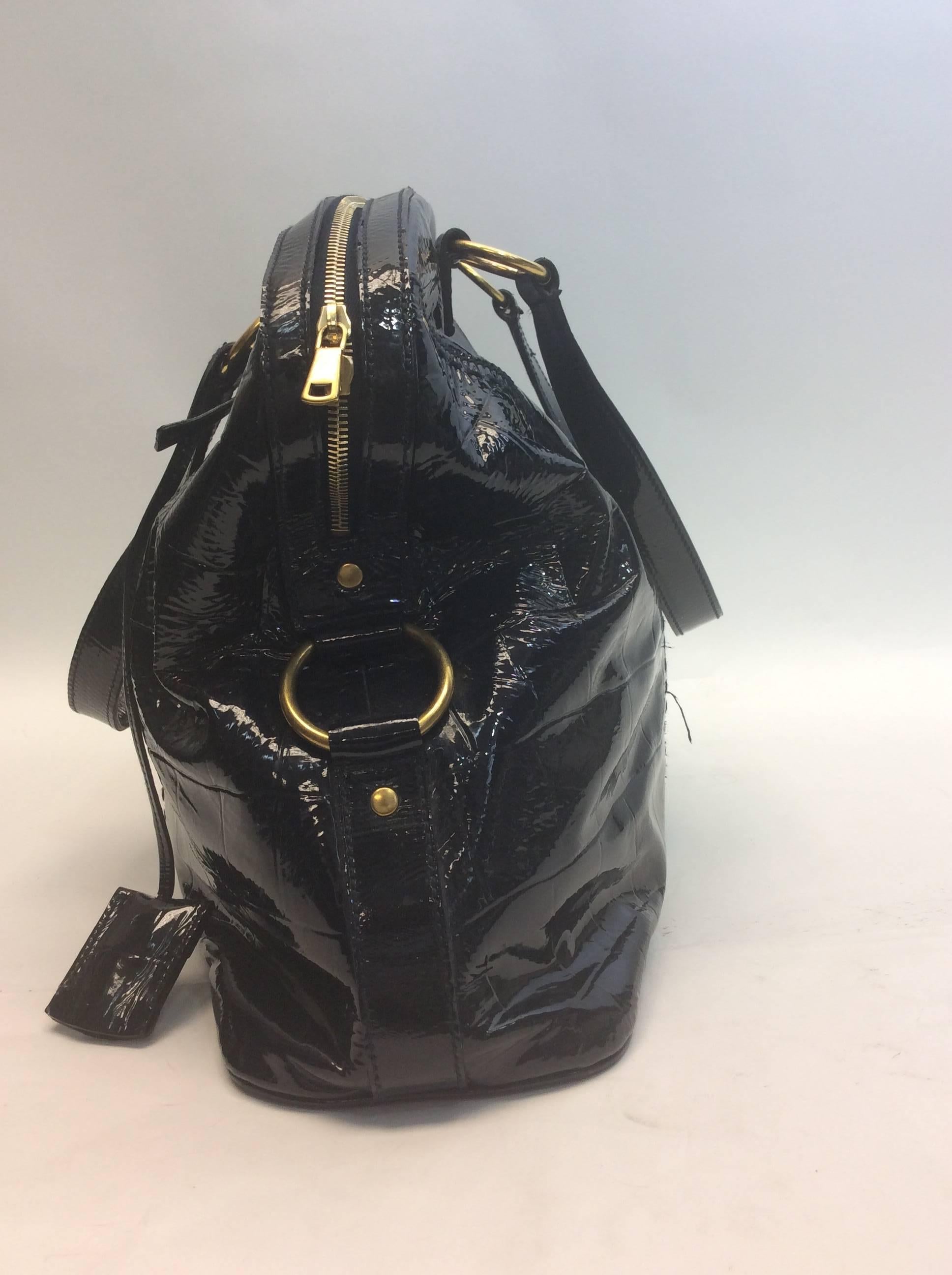 Black Patent Muse Bag
20 inches wide, 13 inches tall and 7 inches deep
7.5 inch strap drop
Features double zipper closure (one zipper is missing a pull)
Includes YSL padlock and key
One open and one zipped interior pocket
Patent leather exterior