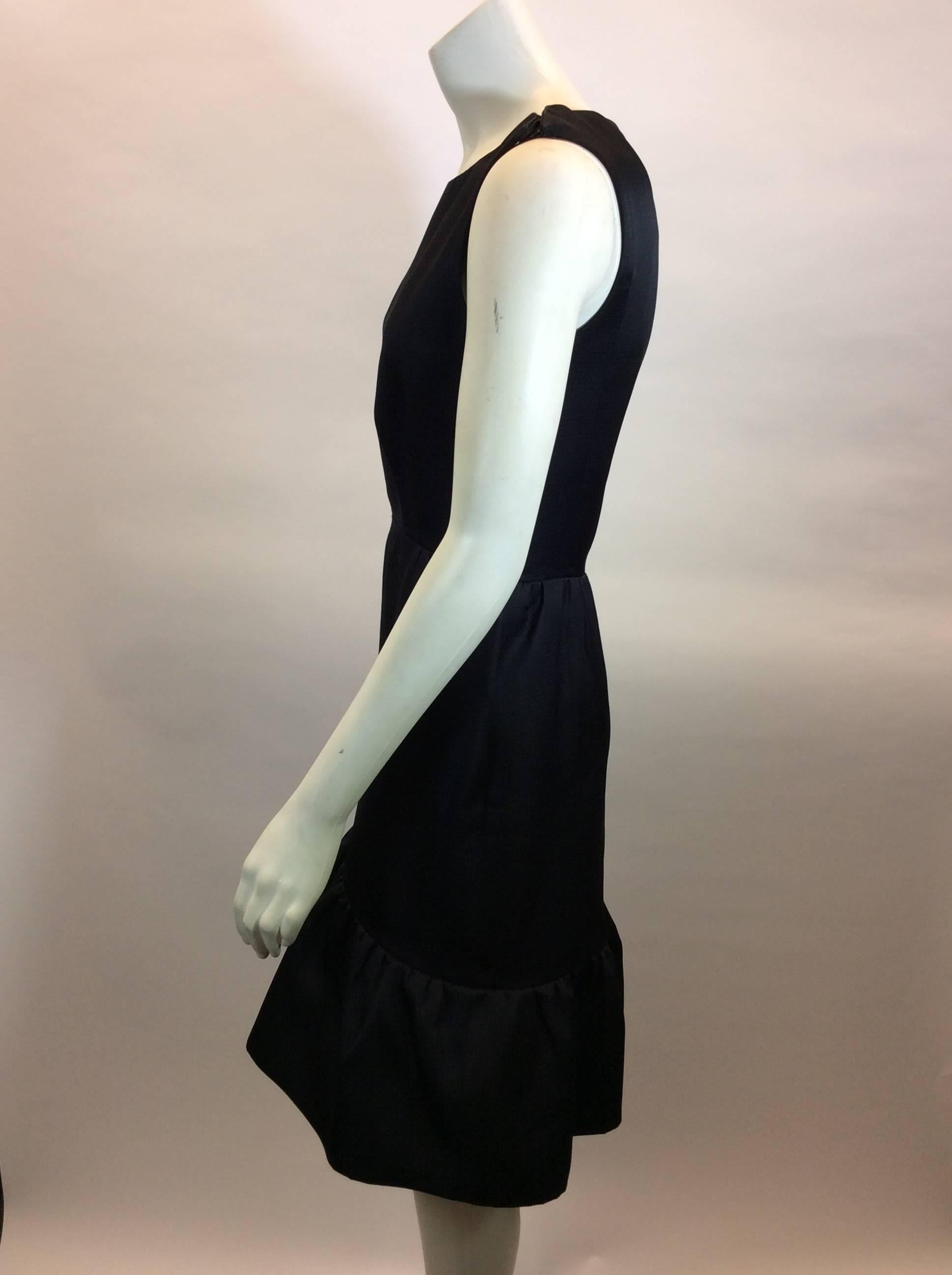 Black Flounce Sleeveless Dress
Features decorative hook and eye closures on left shoulder seam
Side seam zipper closure
Size 38 (equates to US 6)
100% Silk