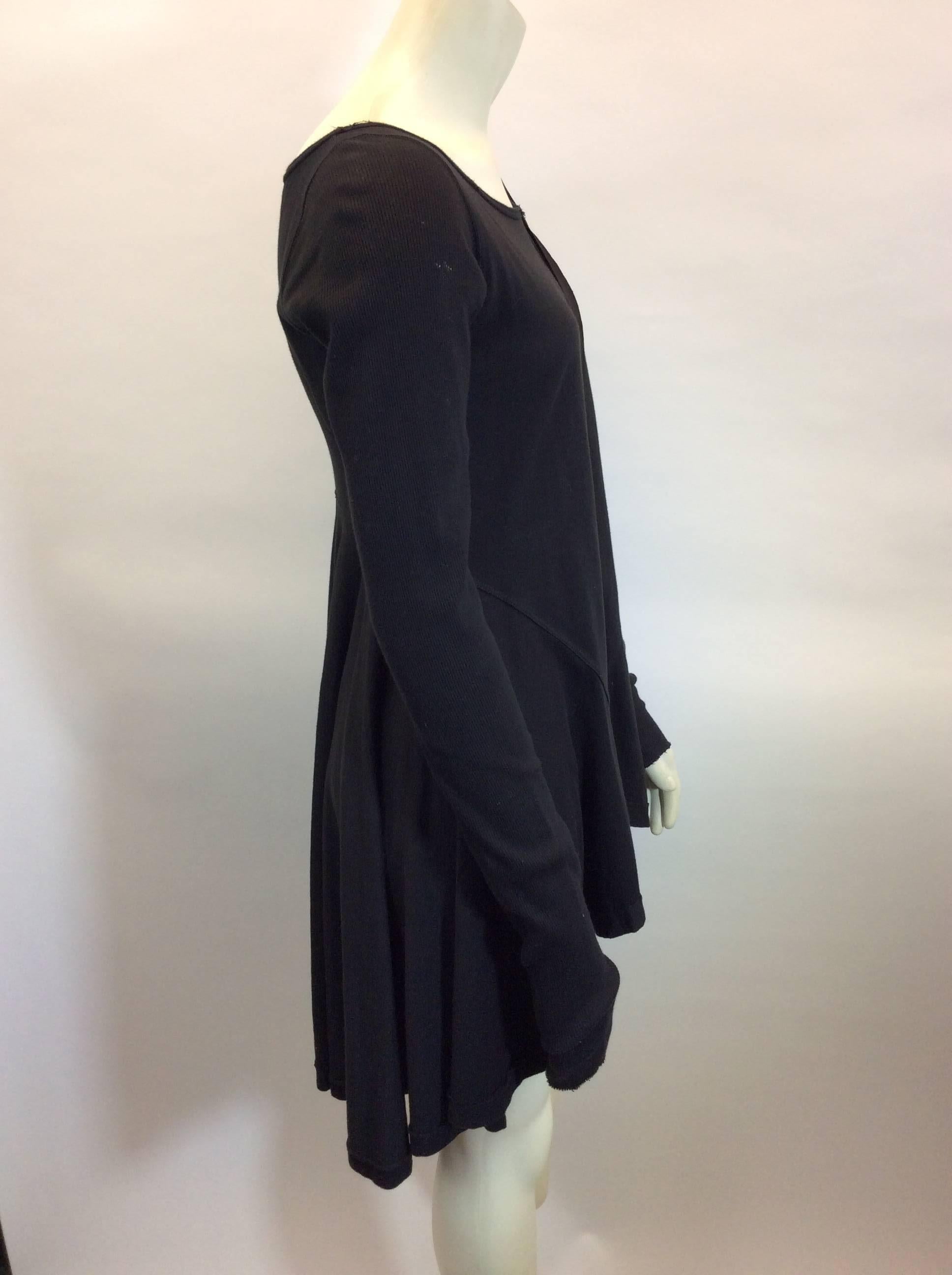 Black Knit Dress with Strap Detail
High-low hemline
Long sleeves with ribbed texture
Features decorative shoulder strap
Size and fiber content unknown (see garment measurements)