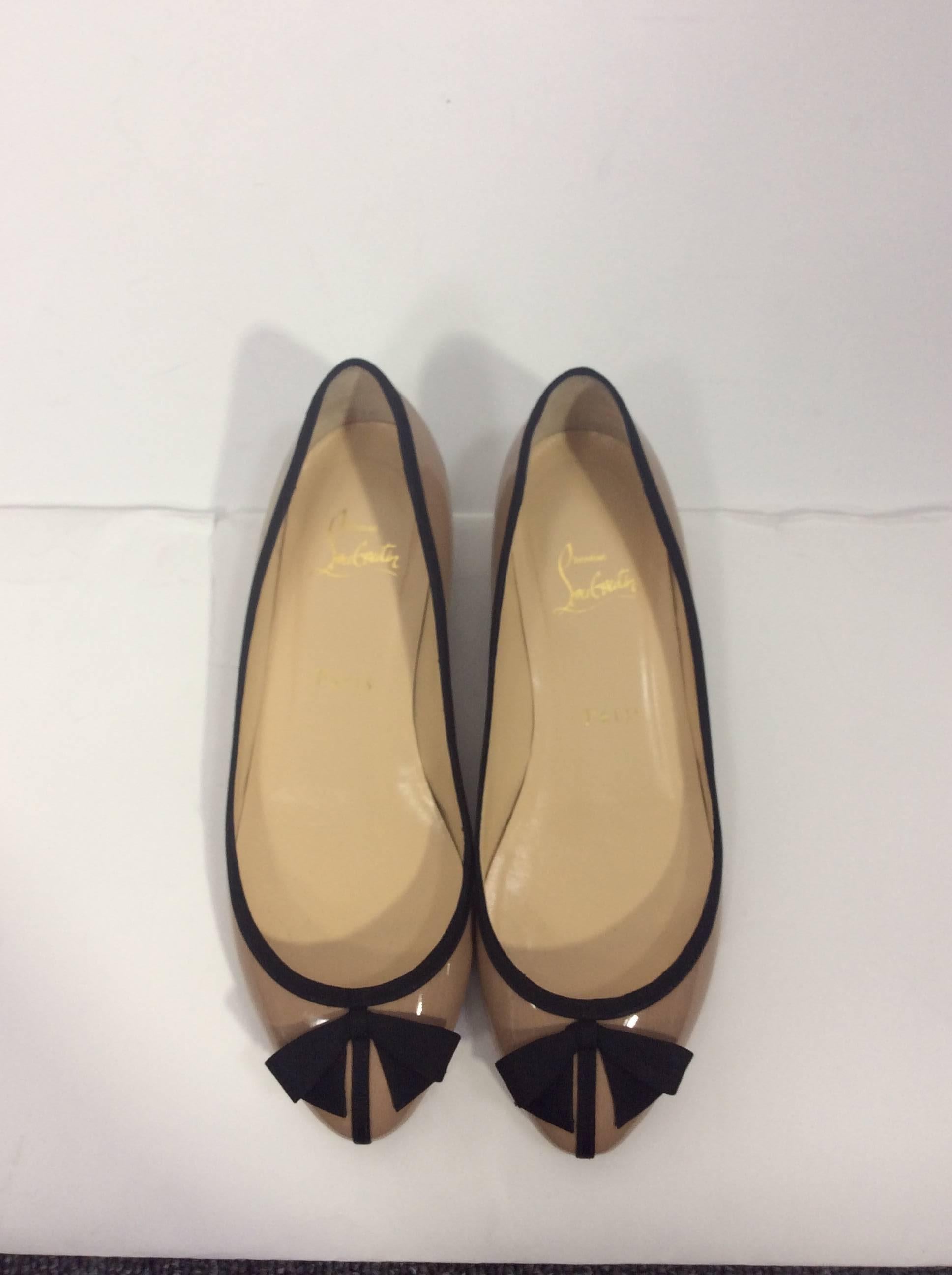 Christian Louboutin Nude Flats
Black trim with black small bow
Patent Leather
Comes with box, original price $765 
Size 37.5