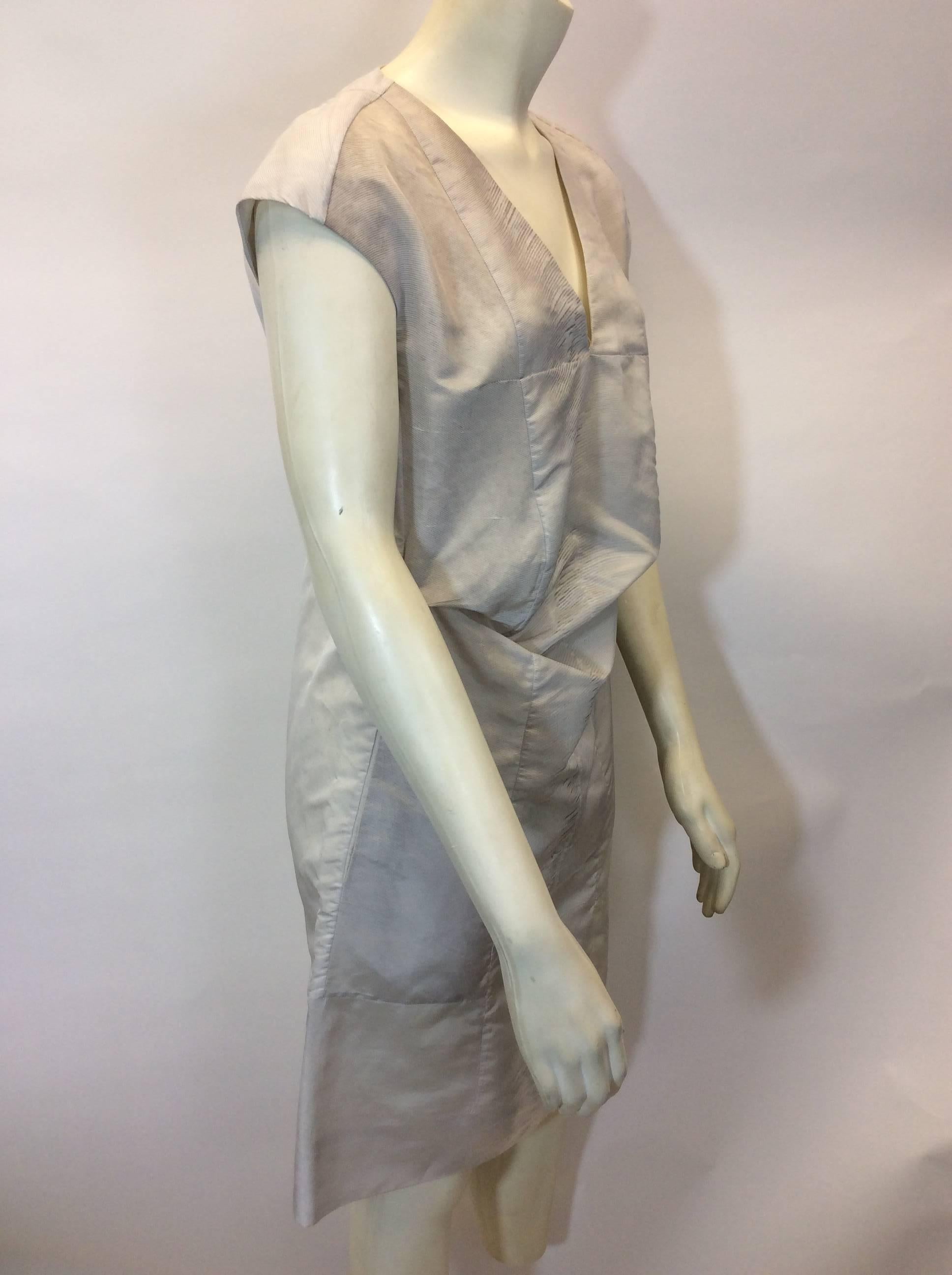 Grey Pleated Waist Dress
Light grey with variegated stripe pattern
Faced cap sleeves
Band detail on bottom of skirt
Features two hip pockets
Size 38
58% Nylon, 42% Silk