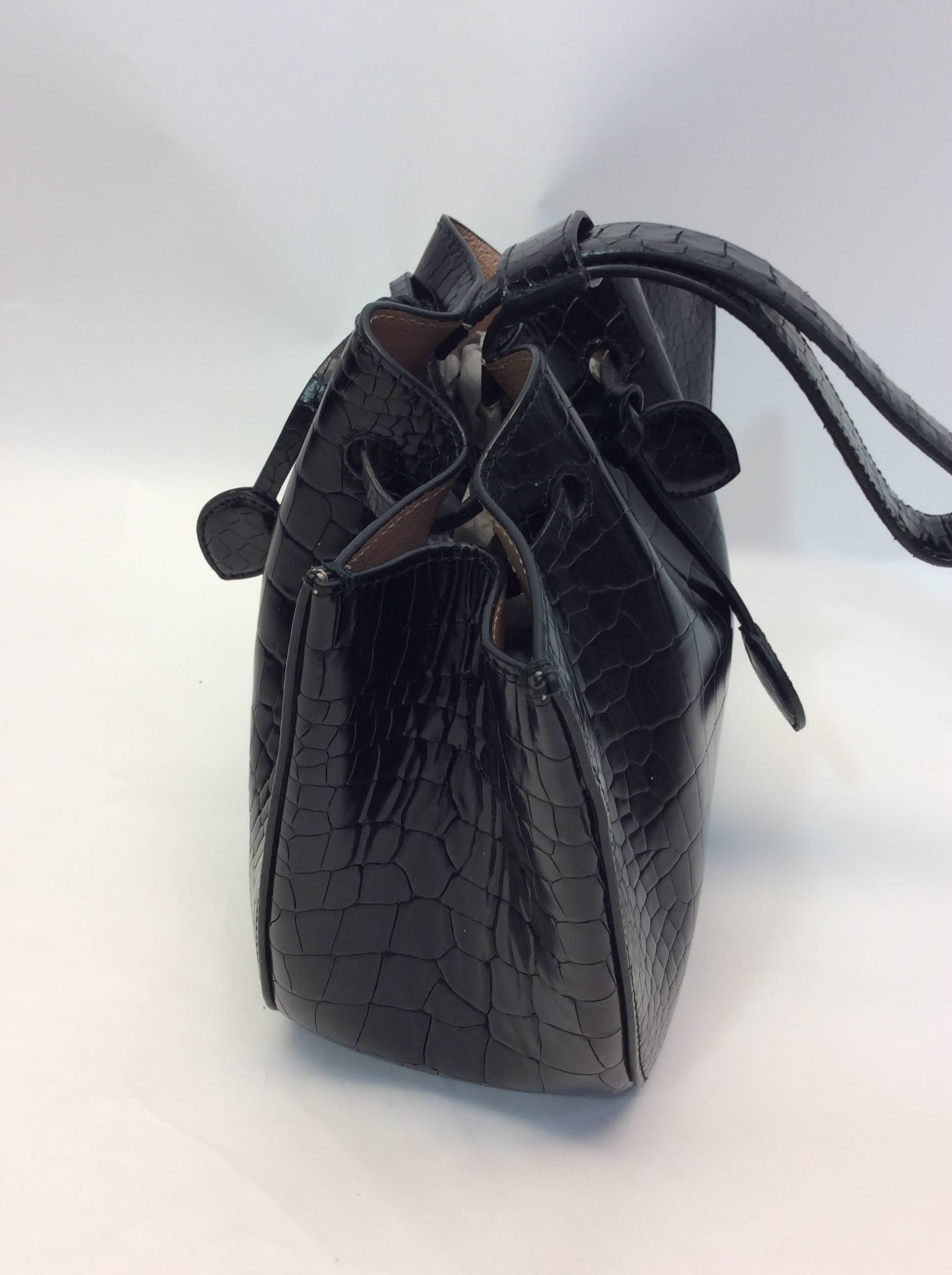 Black Wristlet Bucket Bag
8 inches tall, 11 inches wide, 4 inches deep
6.5 inch strap drop
Drawstring closure
Adjustable strap
Features detachable Alaia logo mirror
Calf leather exterior and lining