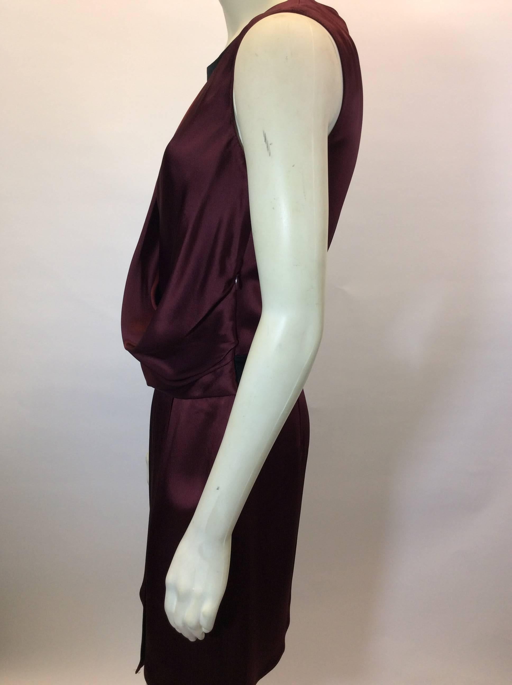 Burgundy Draped Dress with Black Drop Waist Detail
Center back and side seam zipper closures
Slit skirt as seen in image 6
Draped bodice design
Size 0
64% Acetate, 36% Viscose