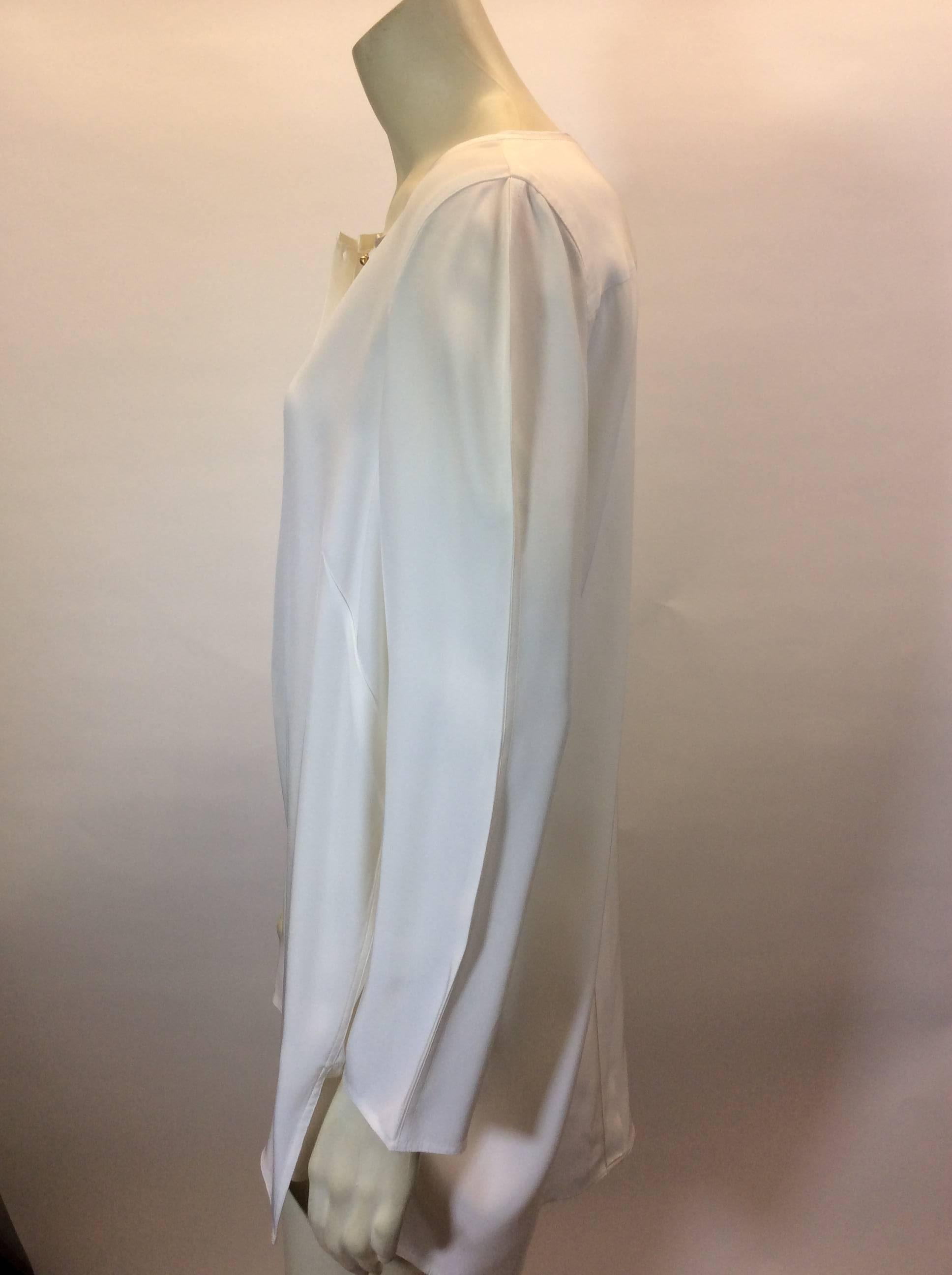 White Silk Blouse with Button Detail
4 button front placket
Stitching detail along sleeves
Trimmed neckline
Pleated back detail
Size Medium
100% Silk