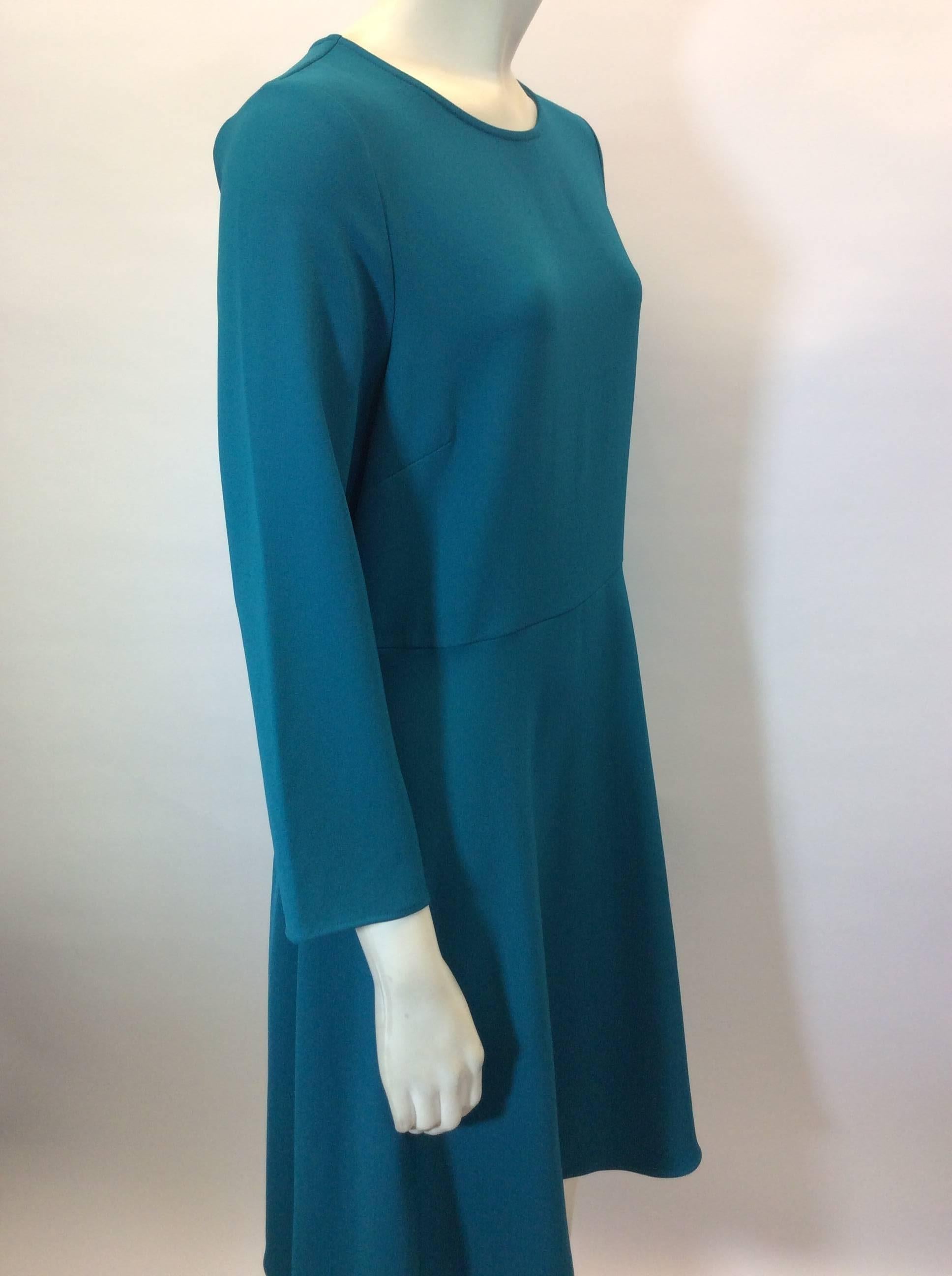 Teal Skater Style Dress with 3/4 Sleeves
Center back invisible zipper closure
Button closure on back neckline
3/4 length sleeves
Knee length
Size Medium
97% Polyester, 3% Elastic