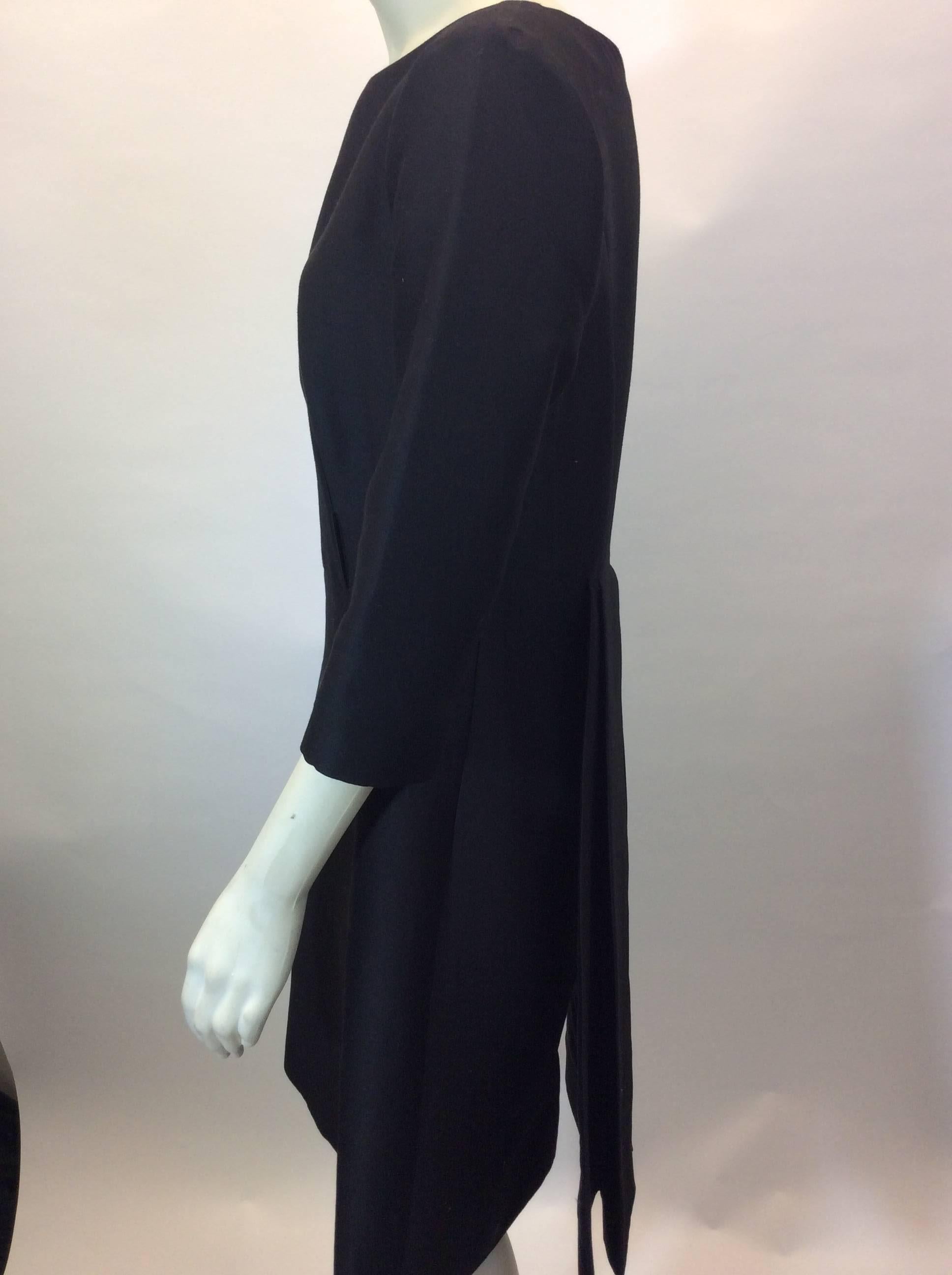 Black Dress with Pleated Back Detail
Center back zipper closure
3/4 length sleeves
Knee length
Back pleated tail detail
Size 40
100% Silk