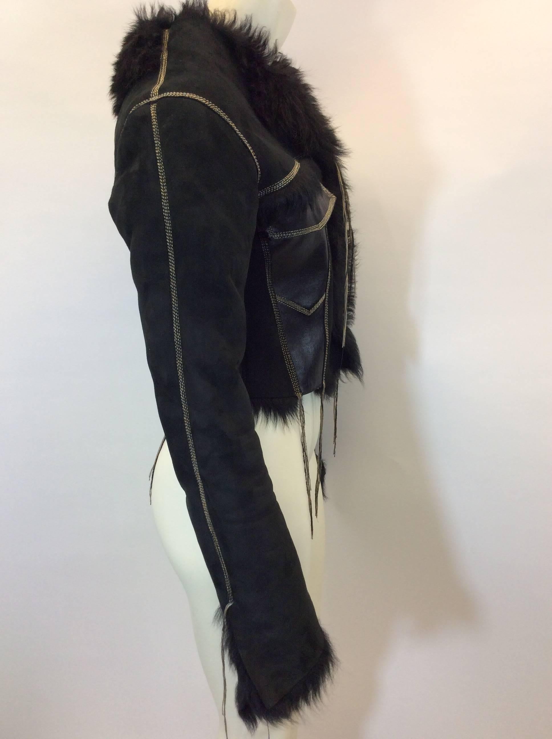 Black Suede Cropped Jacket with Shearling Lining
Center front zipper closure 
Includes two exterior chest pockets and two interior chest pockets
Features fringe created with contrasting thread
Size unknown (refer to measurements)
Suede and leather