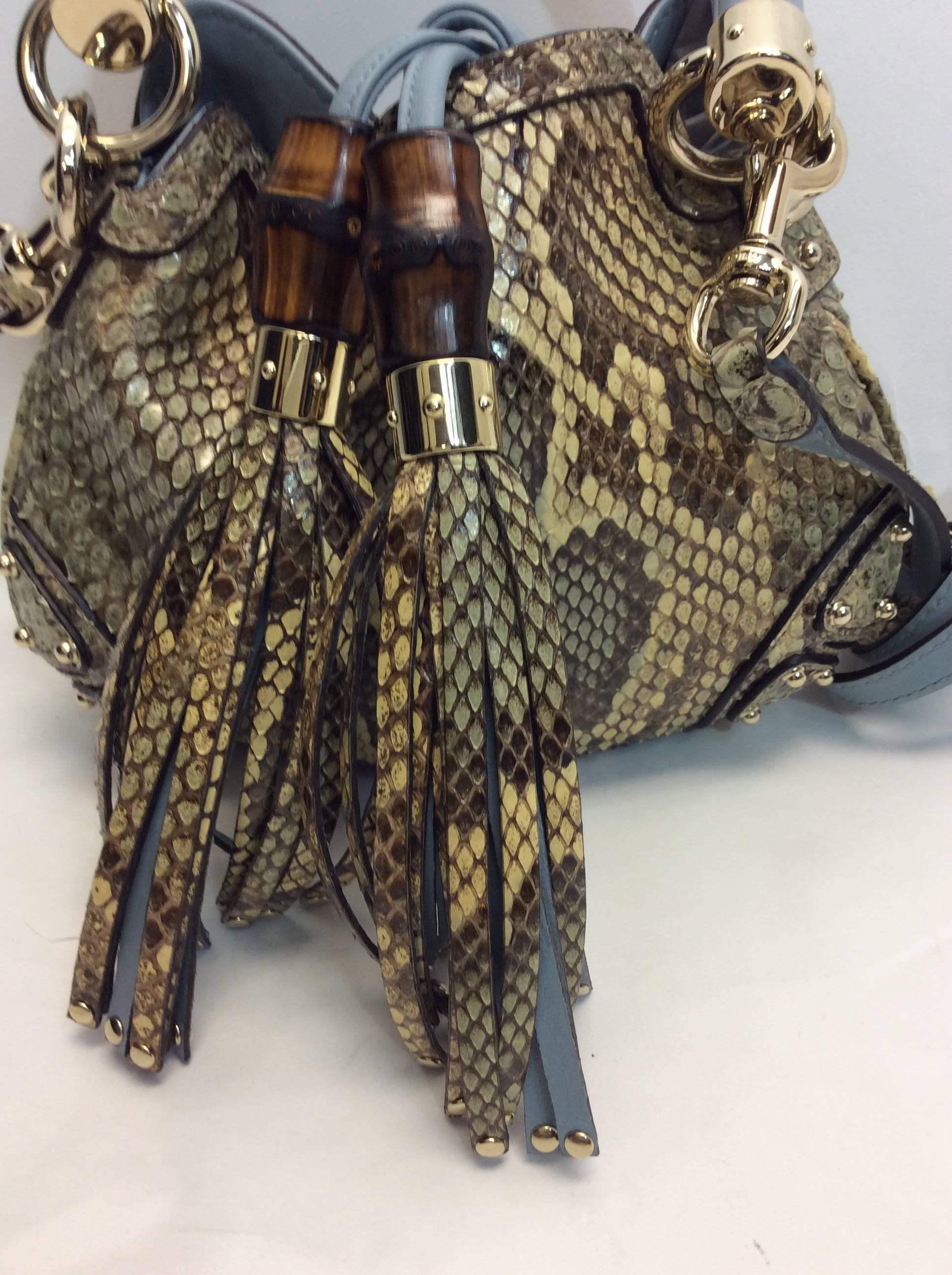 Gucci Python Mini Indy Crossbody Bag
Blue tonal python with gold tone hardware
Optional shoulder strap with single rolled top handle
Features tassle embellishment 
Strap drop is 21 inches
Made in Italy
$2,499
