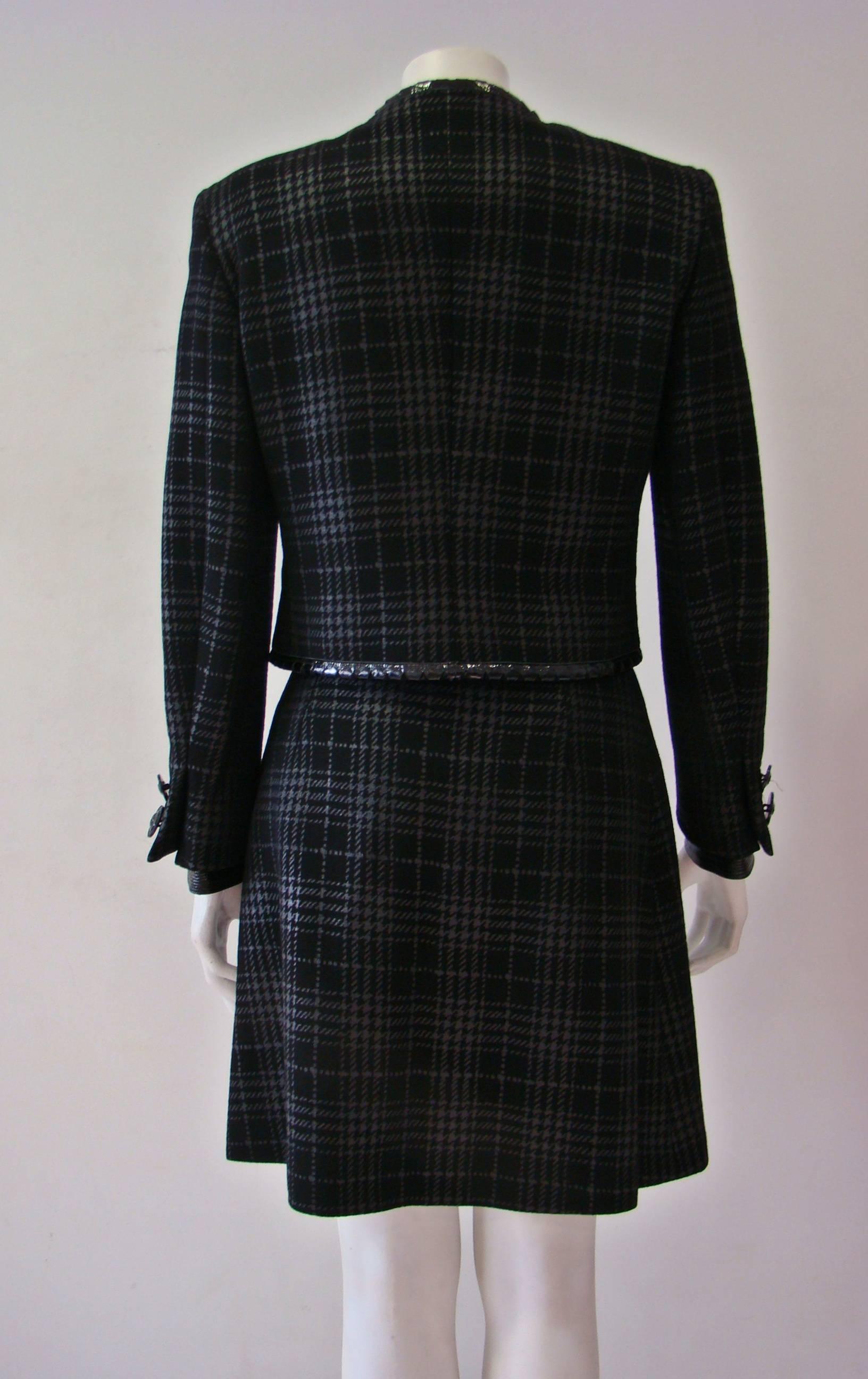 A Unique Gianni Versace Couture Metallic Checked Suit With Patent Leather Jacket Featuring Iconic Medusa Buttons At Front And Sleeves. Combined With A Skirt Featuring An A-Line, Above Knee Length And A Concealed Zip Fastening At Side.