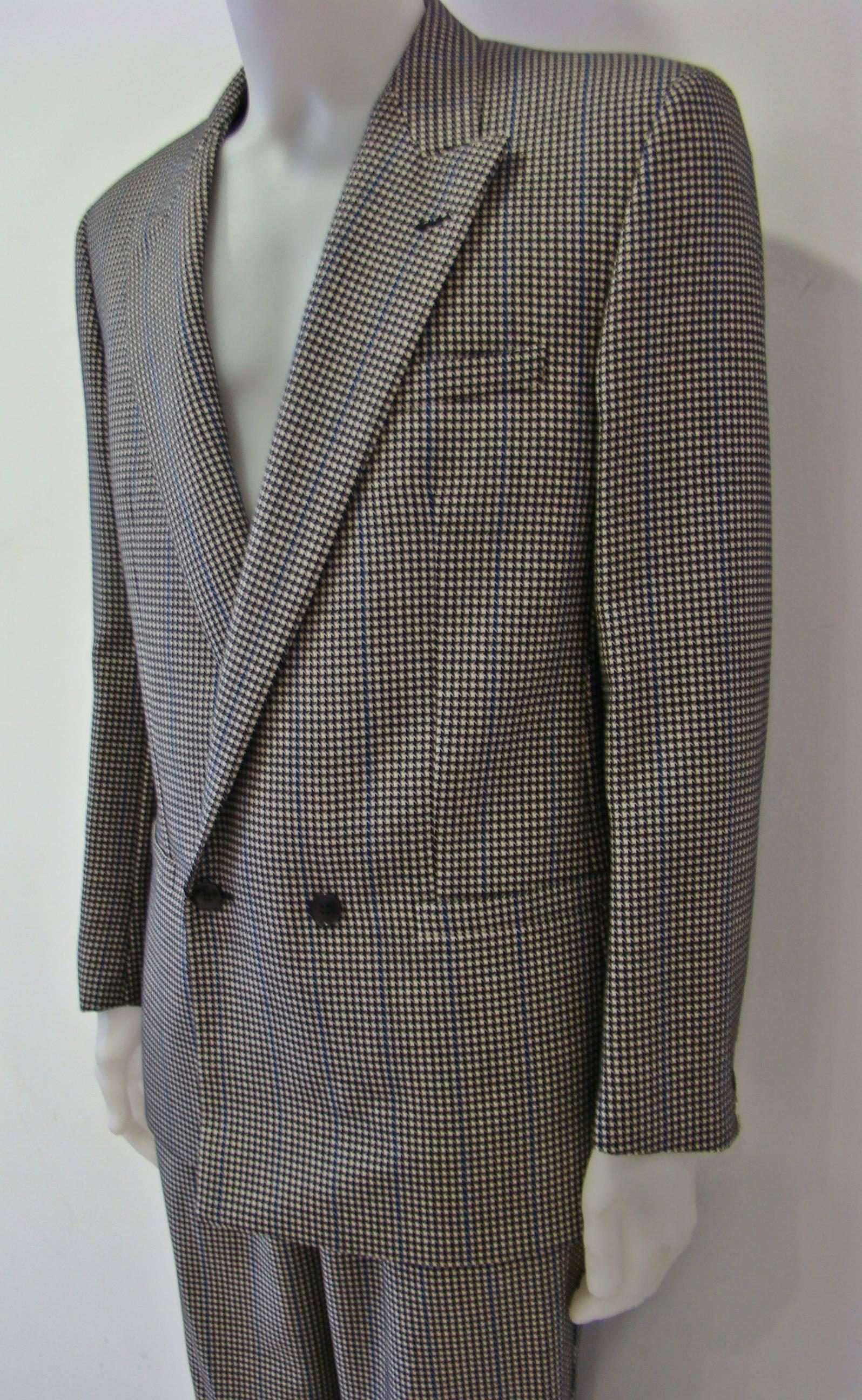 A Rare Suit From Gianni Versace Featuring A Pied De Poule Design. 100%Wool Suit. A Double Breasted Jacket With A Classic Collar, Two Front Welt Pockets And A Broad Welt Chest Pocket Combined With Long Pied De Poule Trousers.