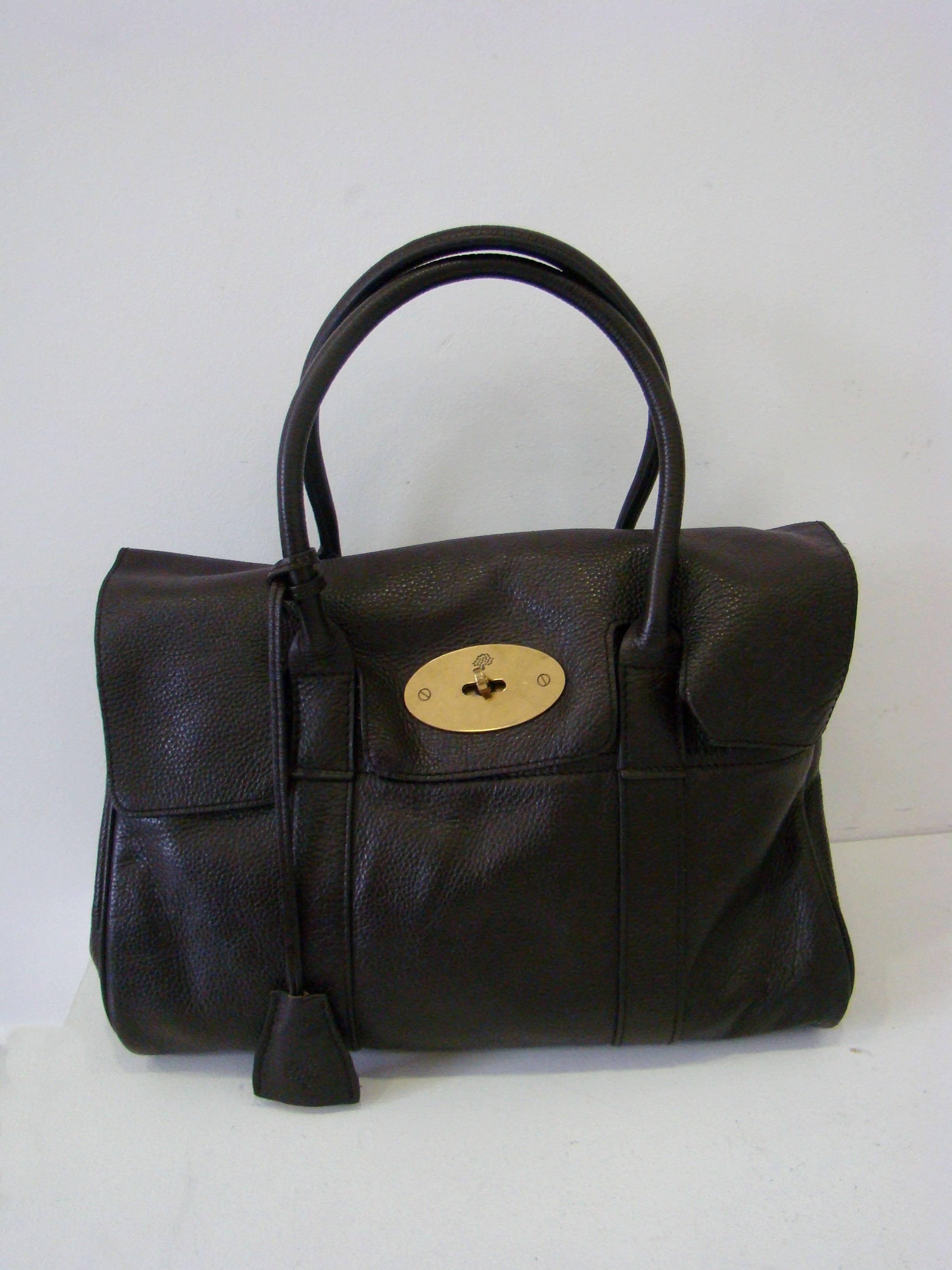 A vintage original Mulberry bag from 1990s featuring a classic postman's lock fastening and a hidden padlock in the leather fob, an inside belt strap to enable widening for extra space, three internal pockets (one zipped), and a soft buffed leather