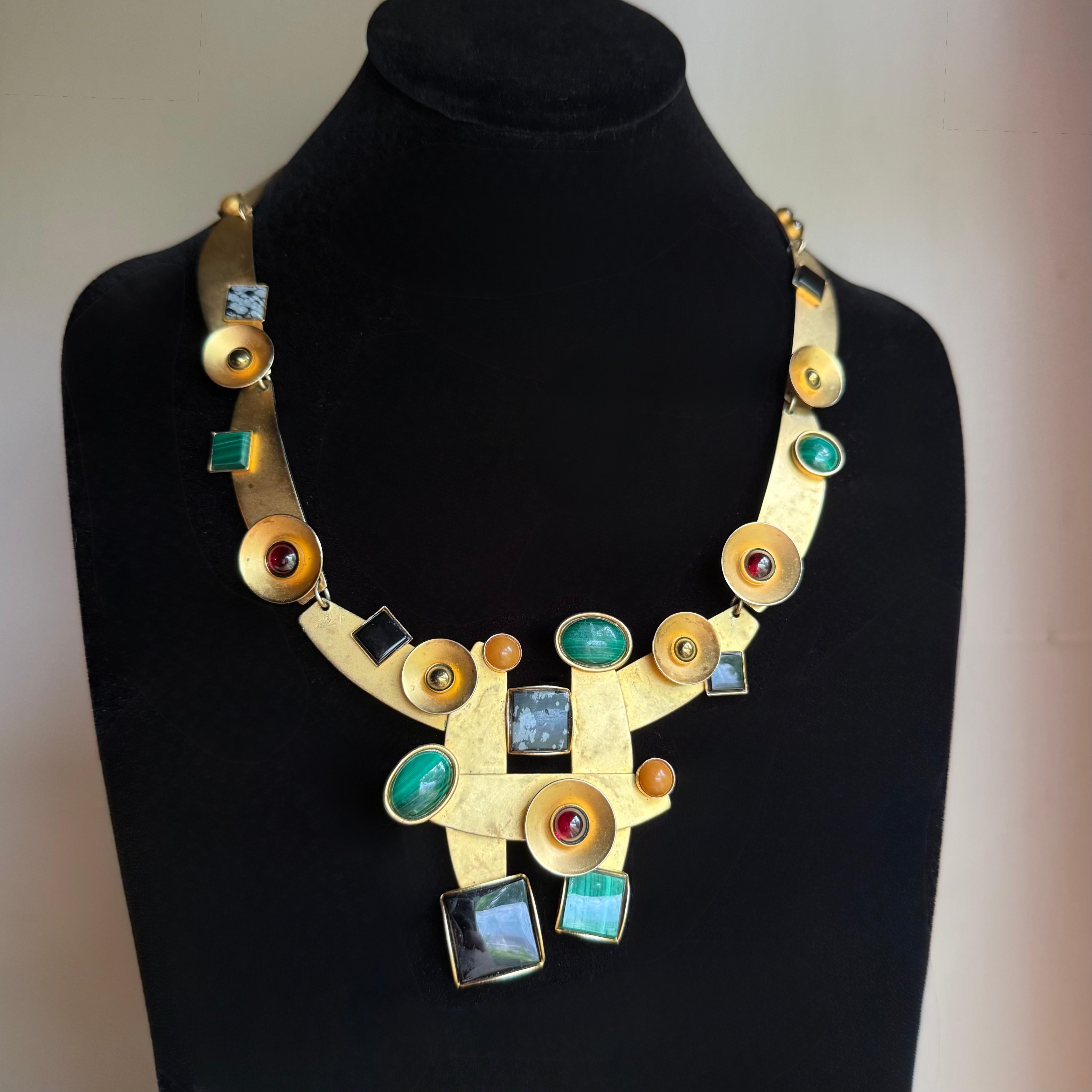 Tout simplement époustouflant, le collier de Gale Rothstein est constellé de diverses pierres semi-précieuses telles que la malachite, les grenats, l'agate mousse et l'obsidienne flocon de neige.
19.5 inches long, a show stopper
En très bon état