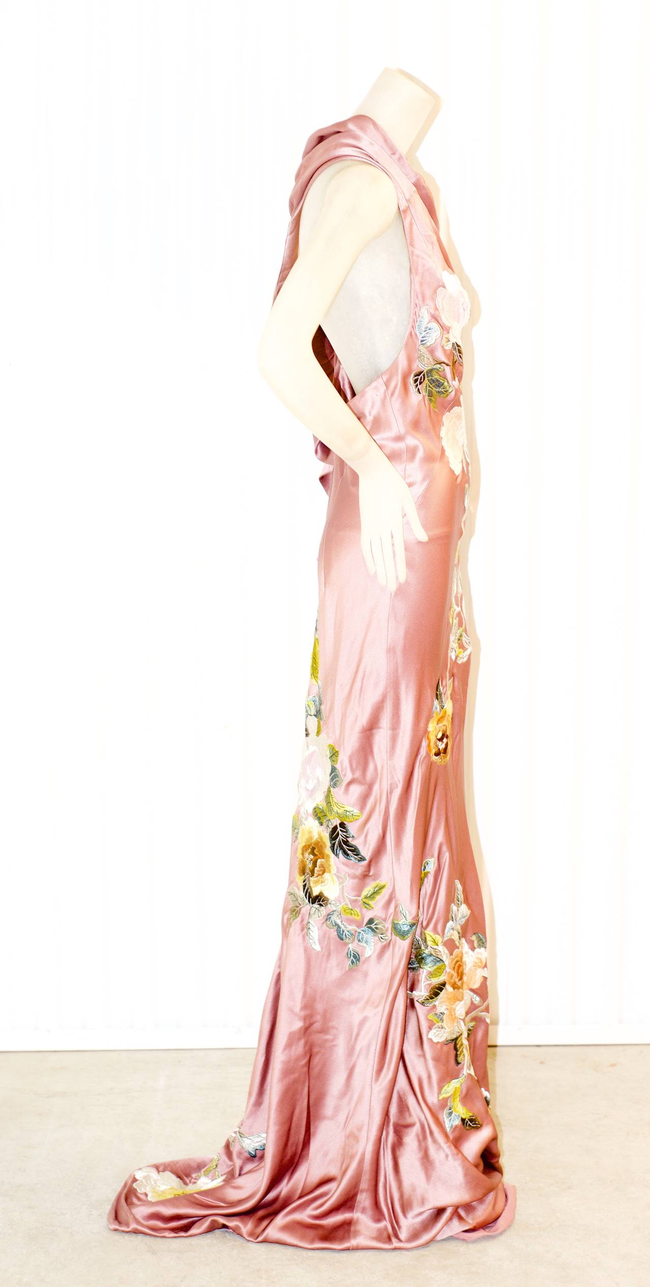 A beautiful and stunning Alexander McQueen gown invoking an embroidered shawl in a soft pink to foamy green ombre.  Gown has an unusual sash that can also be worn as a single sleeve.  Gown has a slight train.