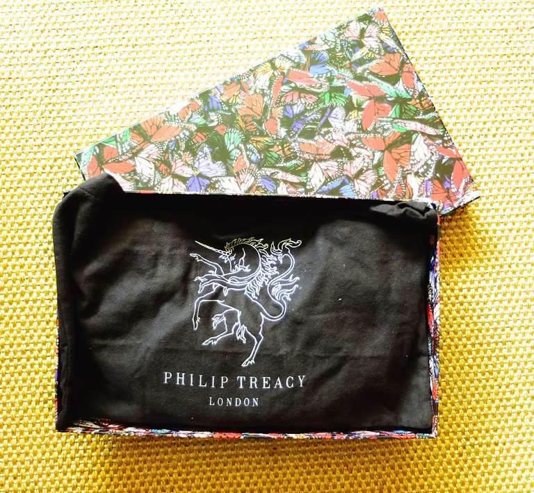 A madcap and whimsical Philip Treacy clutch in a techno material with a vibrant silk butterfly lining.  Comes with original mirror, dust bag and box.

Pristine, like new, condition.

Measurements:
12 1/2