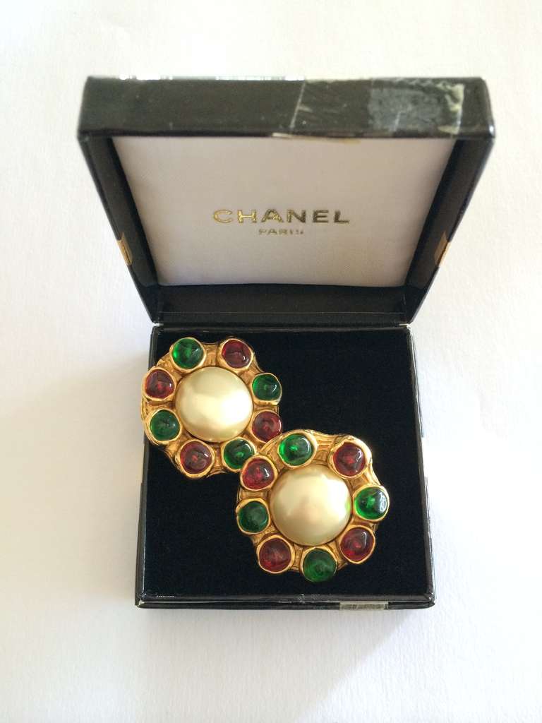 A very beautiful pair of Chanel faux mabe pearl earrings with ruby and emerald colored gripoix stones.