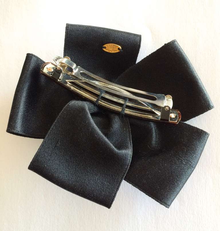 A Chanel black ribbon and white camellia hair clip.