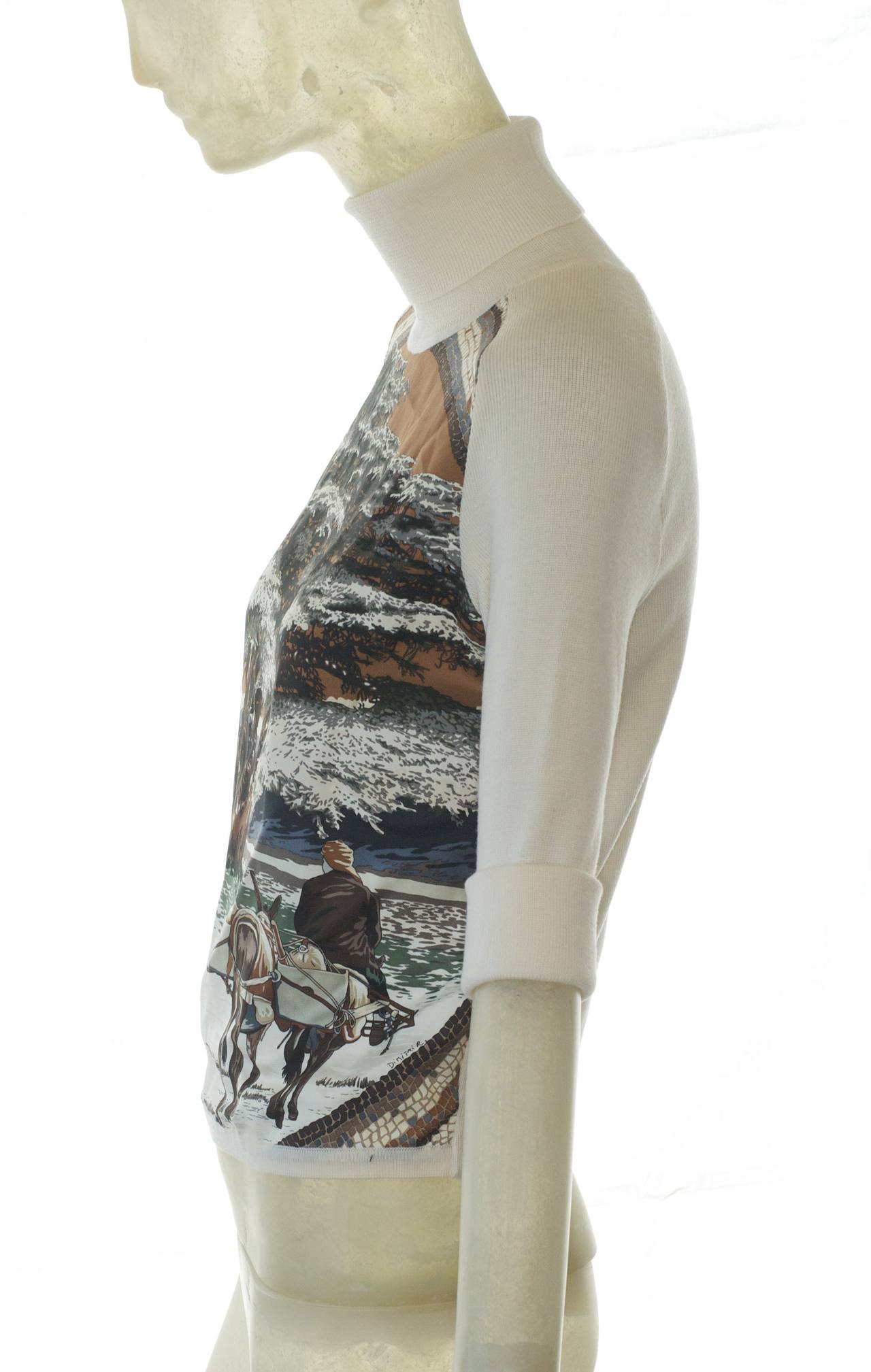 A lovely Hermes silk and fine, soft, lightweight wool sweater with a winter snow scene ny Dimitri Rybaltchenko is a perfect addition to your holiday and winter wardrobe of a bucloic scene of horses, goat herders and an ancient tree with snow covered