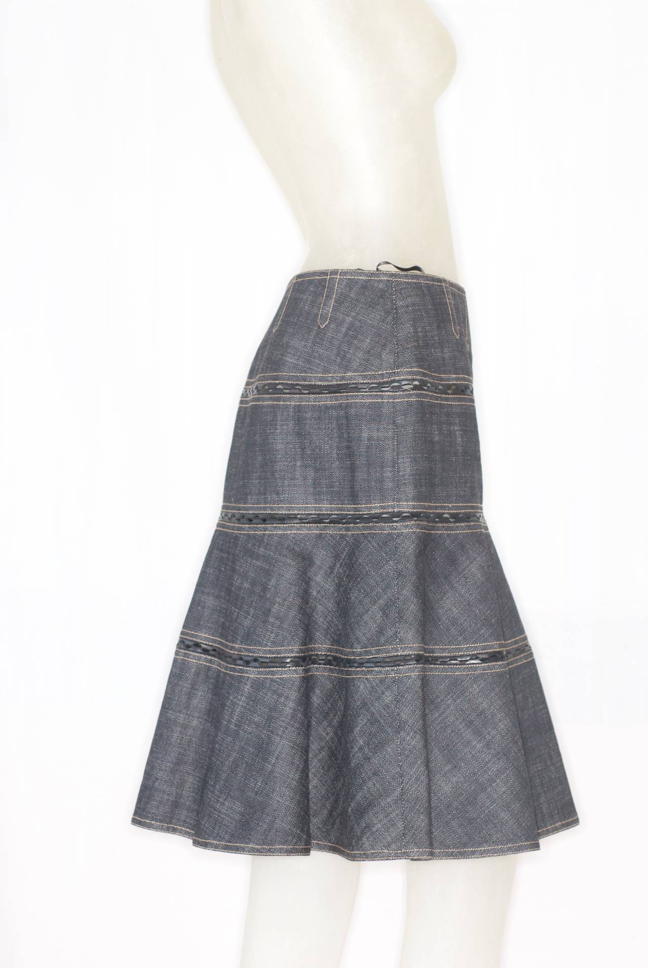 Azzedine Alaia denim skirt with leather inserts. Boning at waist for a beautiful fit.   Excellent condition.  Size tag medium.  May run small, please see measurements:
waist across front: 13 1/2
