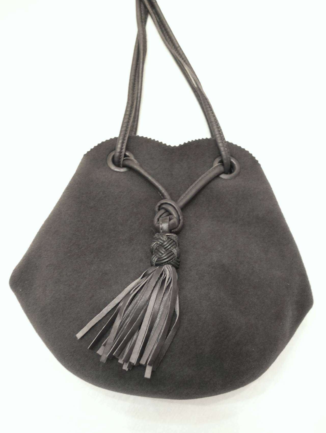 Bottega Veneta Bag made in a fine felt (the type used to make hats) which holds its shape but is soft.  Lined in silk with two interior pockets.  The strap and tassel are made of leather and the tassel has a Bottega Veneta's iconic braided