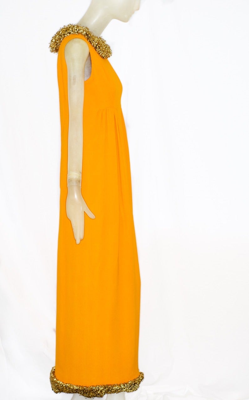 A rare and stunning haute couture gown circa 1963 by Valentino.  The dress epitomizes 1960s Italian chic and dolce vita in a glamorous shade of marigold. It is 4-ply silk crepe, lined in silk habutai and with filigree gold embroidery on the neckline