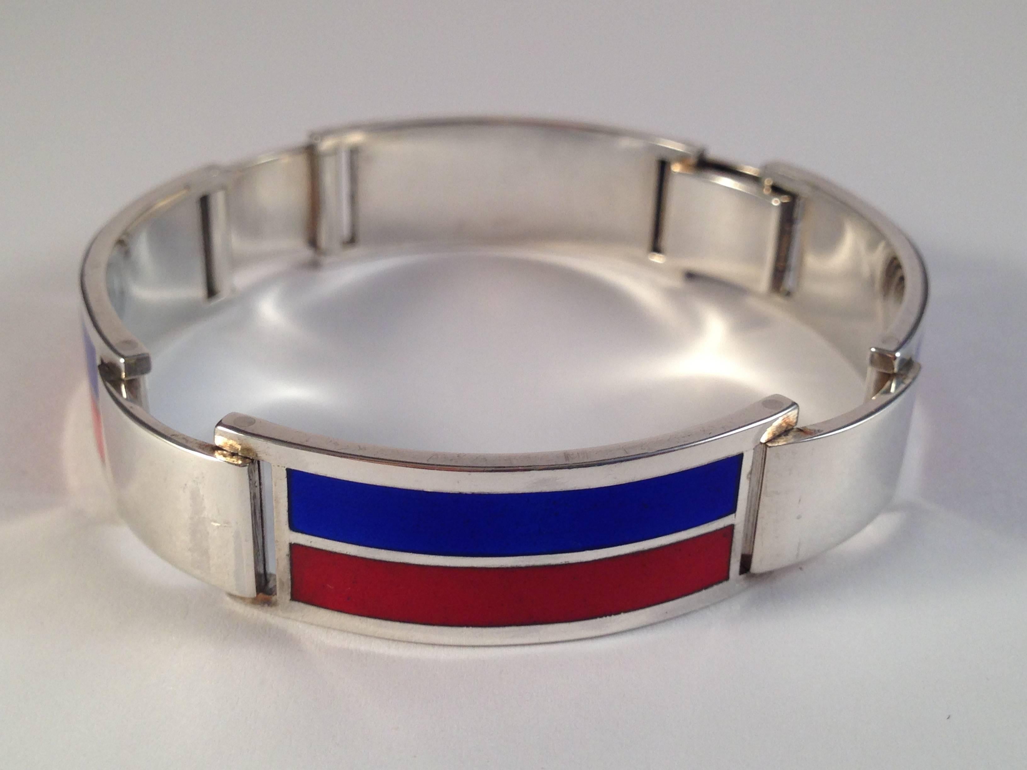 This is an amazing 1970s Gucci sterling bracelet with red and blue enamel stripes. It is for a small wrist. Once fastened the inside circumference measures 6 3/8