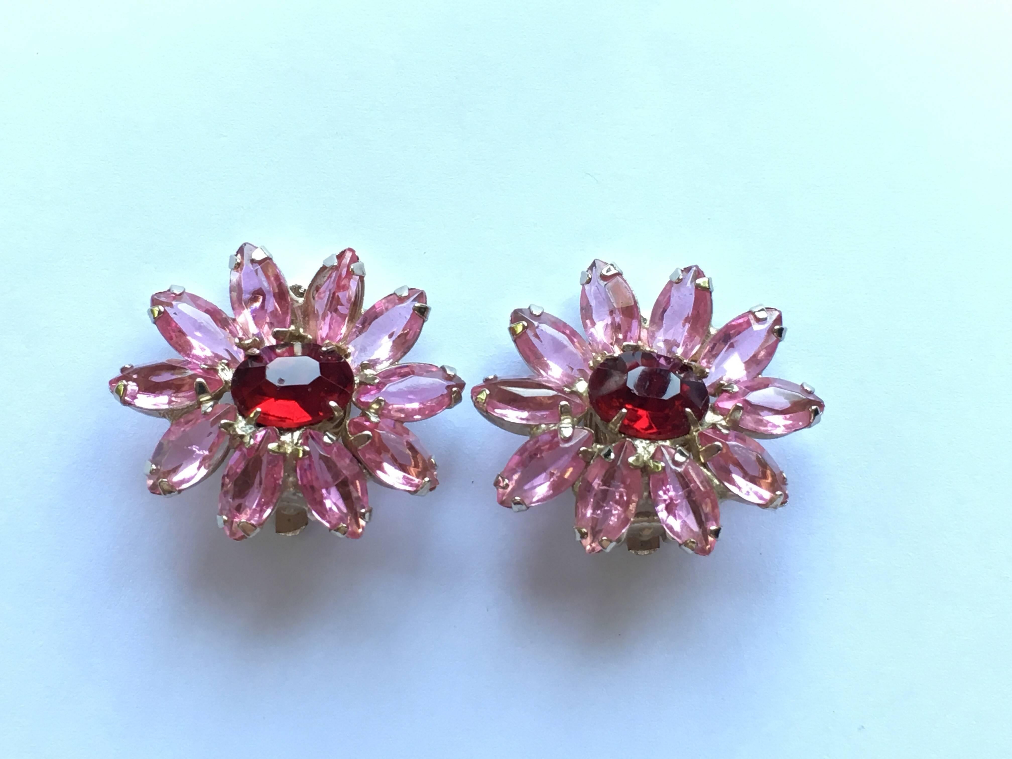 This is a pair of 1960s Weiss flower clip-on earrings. They have pink glass petals and red glass centers. They are in excellent condition and the clips are strong. They are signed 'Weiss' on the back of the clips. They measure 1" high x 1
