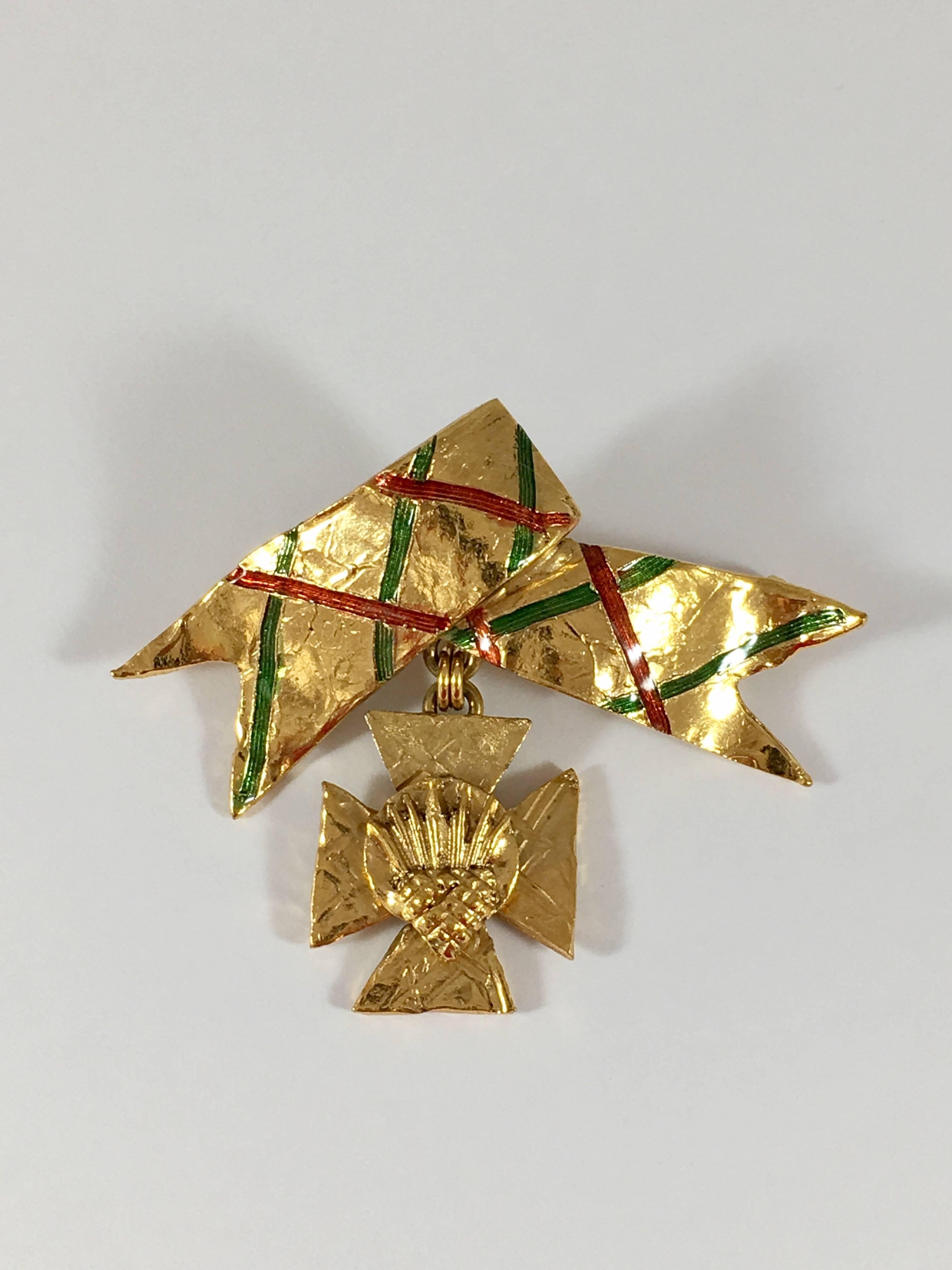 This is a fabulous 1980s Yves Saint Laurent Rive Gauche brooch/pendant. It has a very Scottish feel to it with its plaid ribbon and with the thistle design used in the center of the cross. The brooch can also be worn as a pendant. There is a hook on