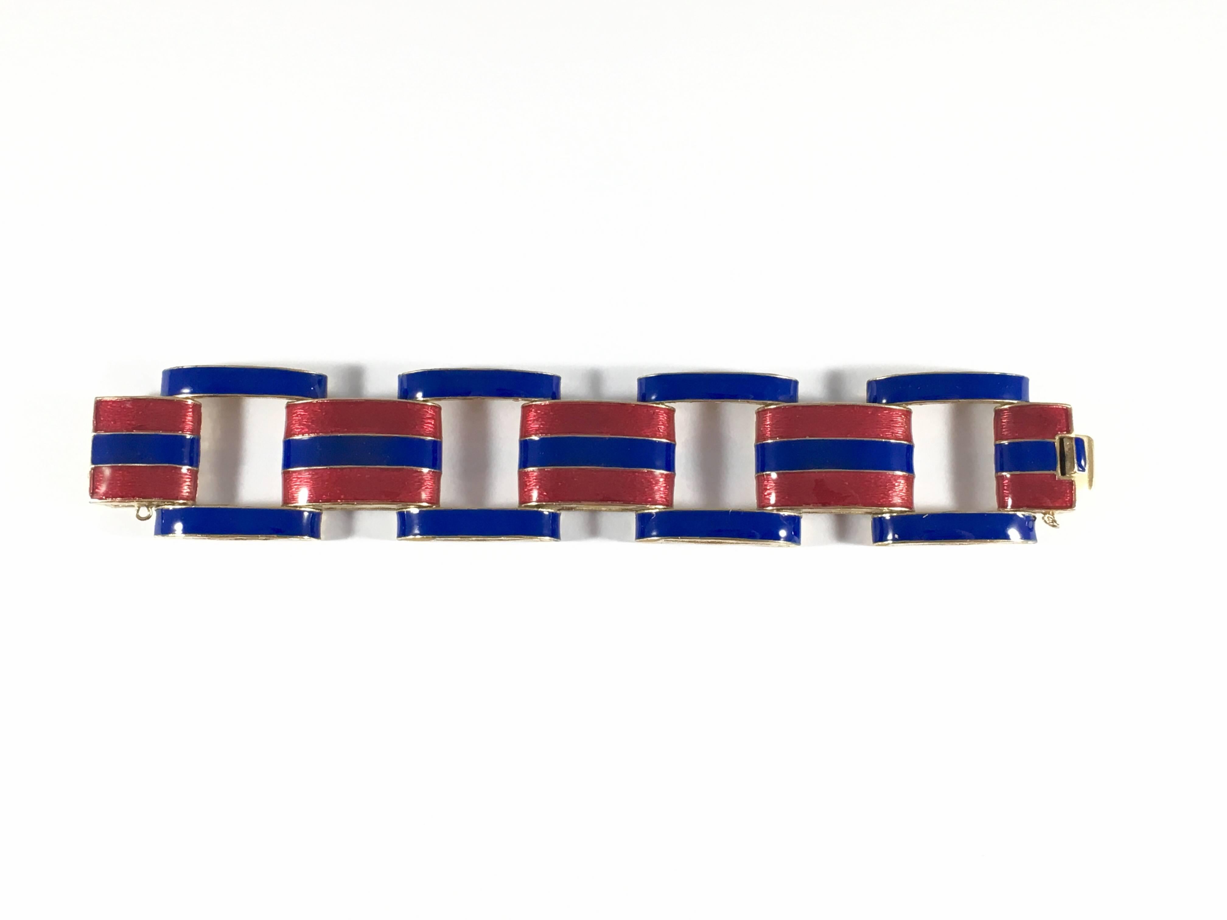 This is a stunning Ciner bracelet from the 1960s featuring gold tone links covered in a red and blue enamel stripe. The bracelet is beautifully made and has a nice weight to it. It is marked 'Ciner' on the inside of the press clasp (see image #8)