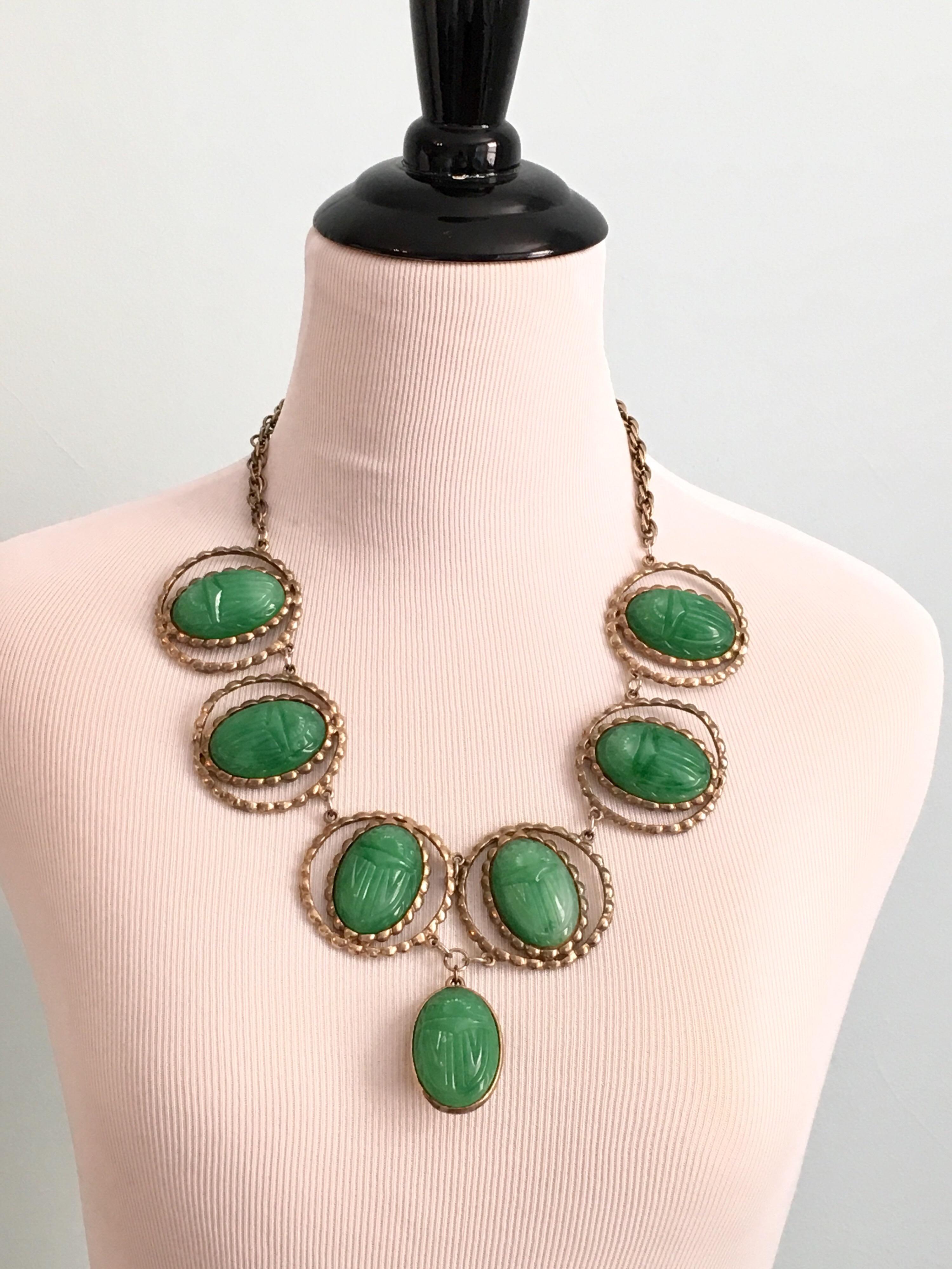 This piece is a show stopper. The necklace is made out of seven large green scarabs. The six scarabs making up the necklace portion have a diameter of 1 3/4 inches. The hanging scarab pendant at the center front measures 1 3/4 inches long. The total