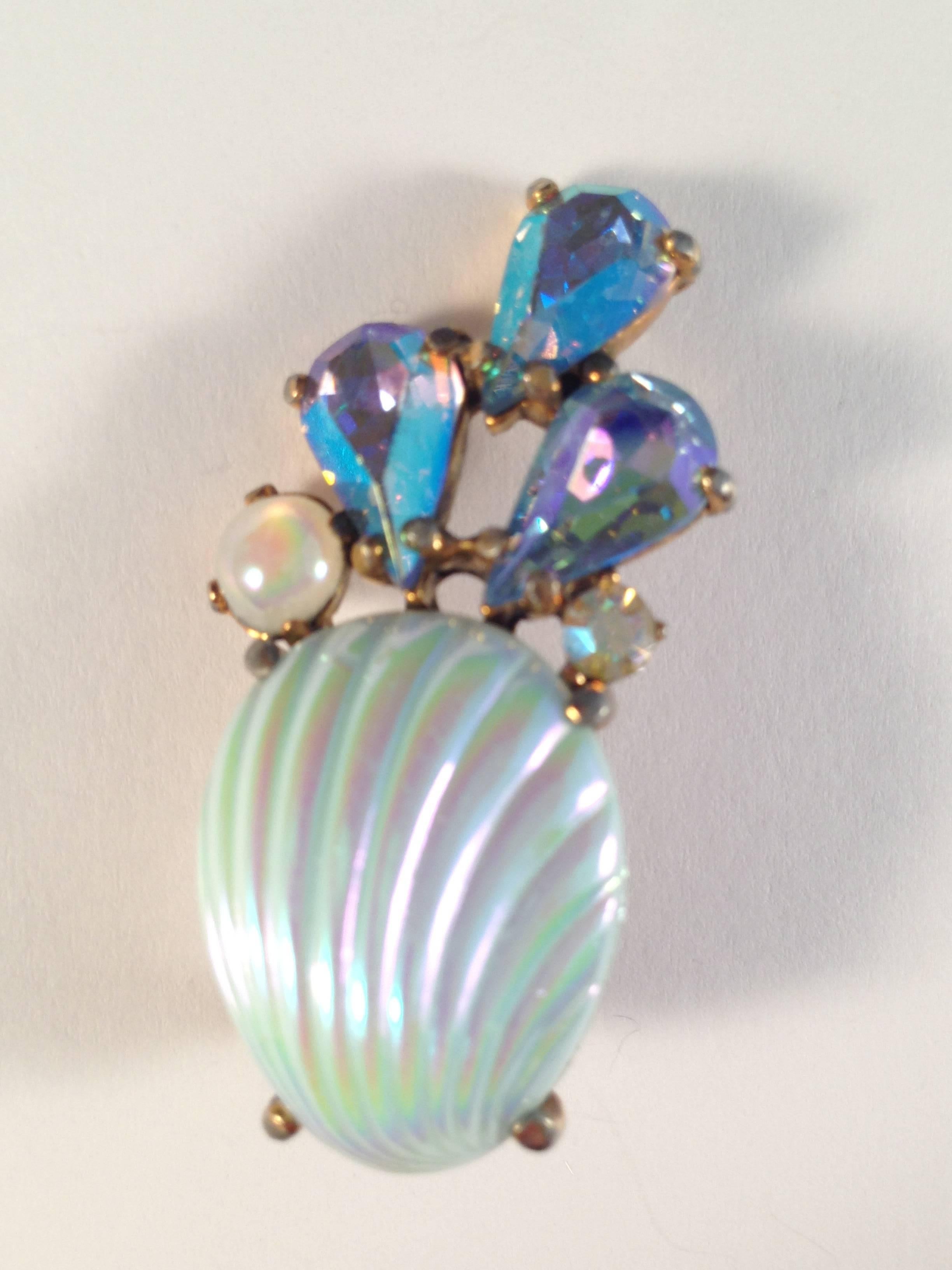 This is a pair of beautiful 1950s Schiaparelli clip-on shell earrings. They feature a faux iridescent blue shell, faux pearl and iridescent blue rhinestones. They are marked "Schiaparelli" on the back of the clips. They are in very good