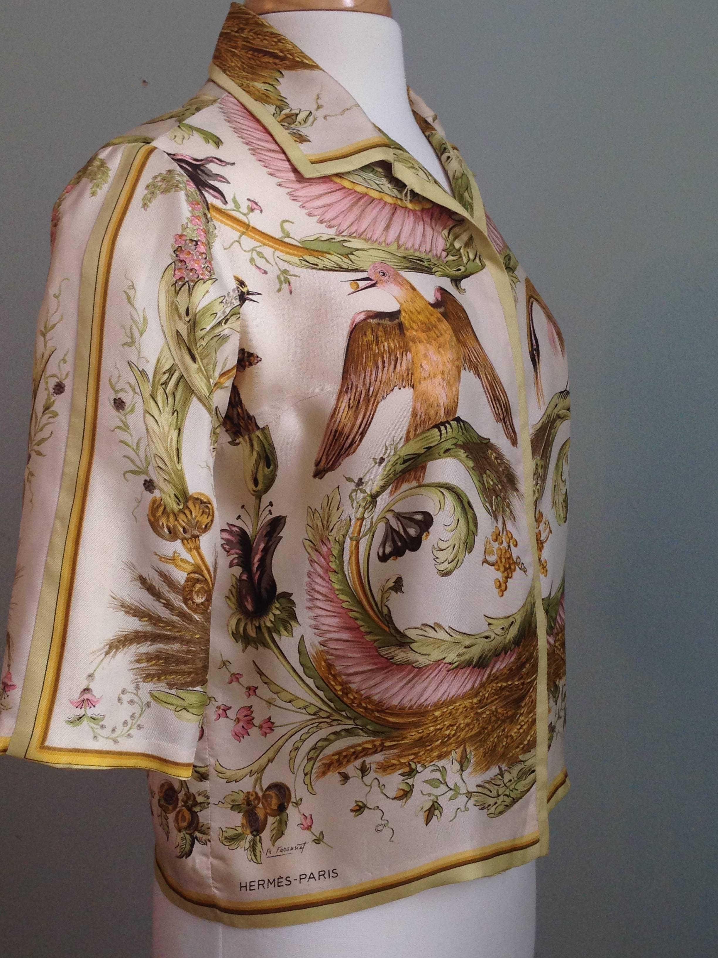 The Hermes 'Ceres' pattern by Francois Facconet is featured in beautiful shades of pink, green and chartreuse on this silk 1960s Hermes blouse. This is a piece for the true Hermes collector. On the front there is a hidden placket with self fabric