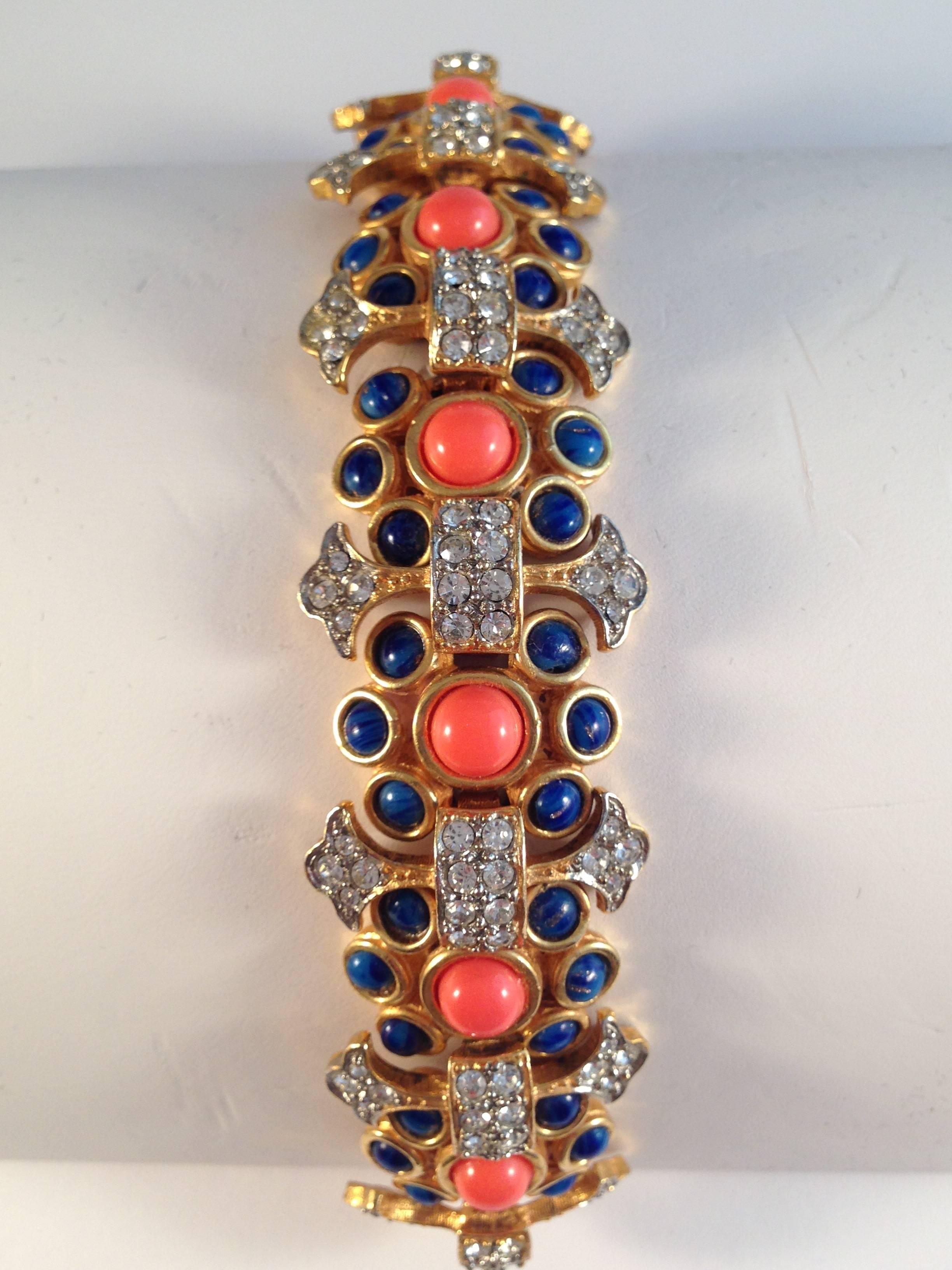 This is an amazing Kenneth Jay Lane Bracelet from the 1960s. It is a beautifully made gold toned link bracelet embellished with faux coral, faux lapis and rhinestones. It has a hidden closure and is signed on the back with 'K.J.L.' - Lane's earliest