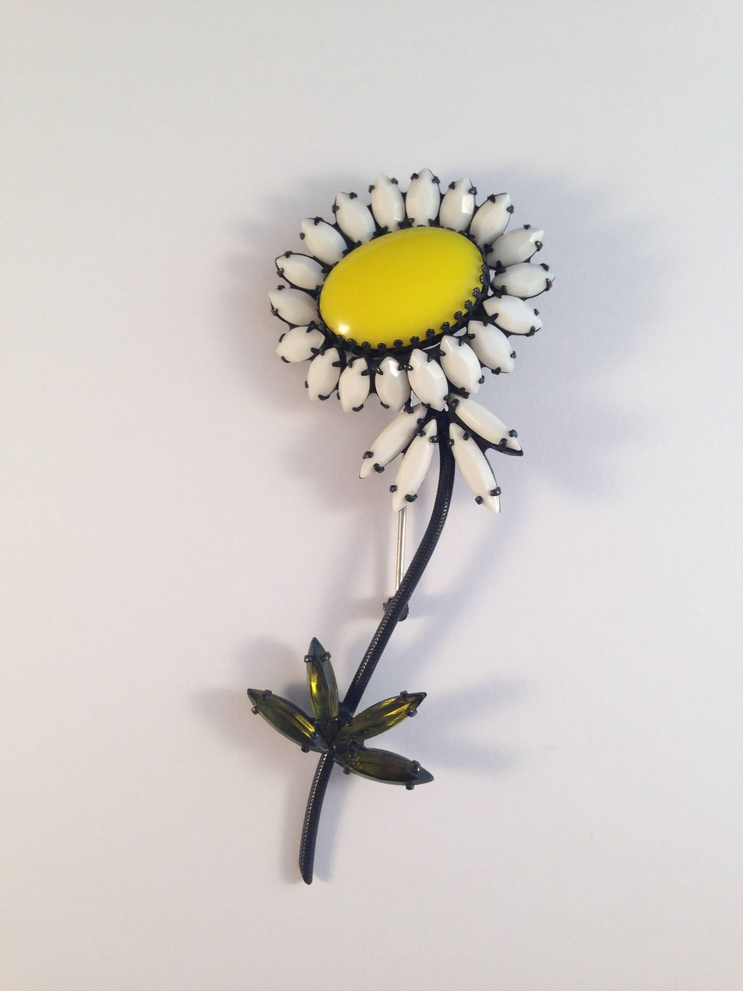 This fun 1960s daisy flower brooch is made up of white, yellow and green glass stones set in a japanned metal. The brooch measures is 4 1/4 inches long x 1 3/4 inches wide. It is in excellent condition and is marked, 