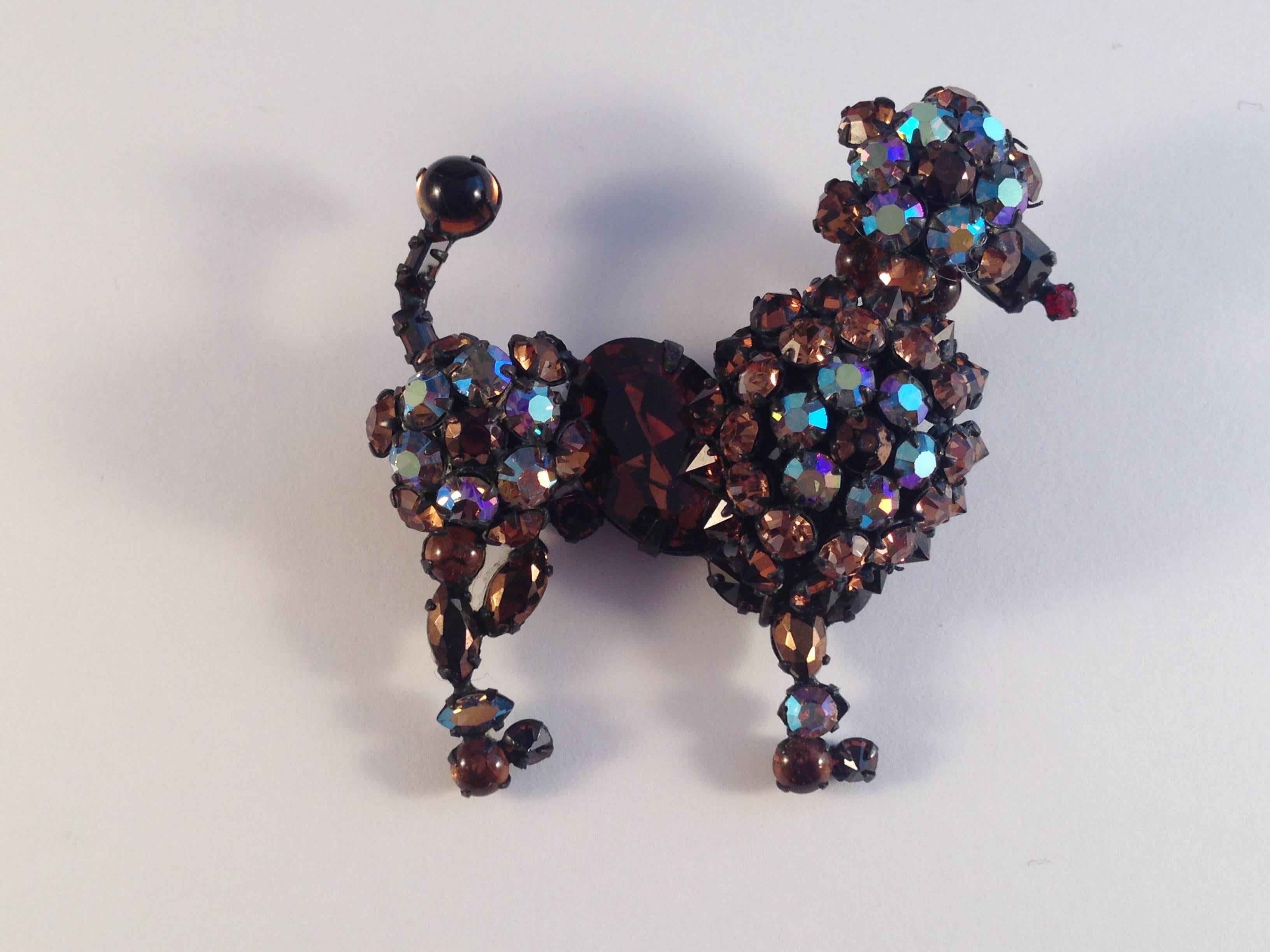 This is a 1950s unmarked Schreiner poodle brooch made of jappaned metal and set with regular brown glass and brown aurora borealis glass stones. Many of the stones are set point side up - a Schreiner signature. It is in excellent condition.

Harry