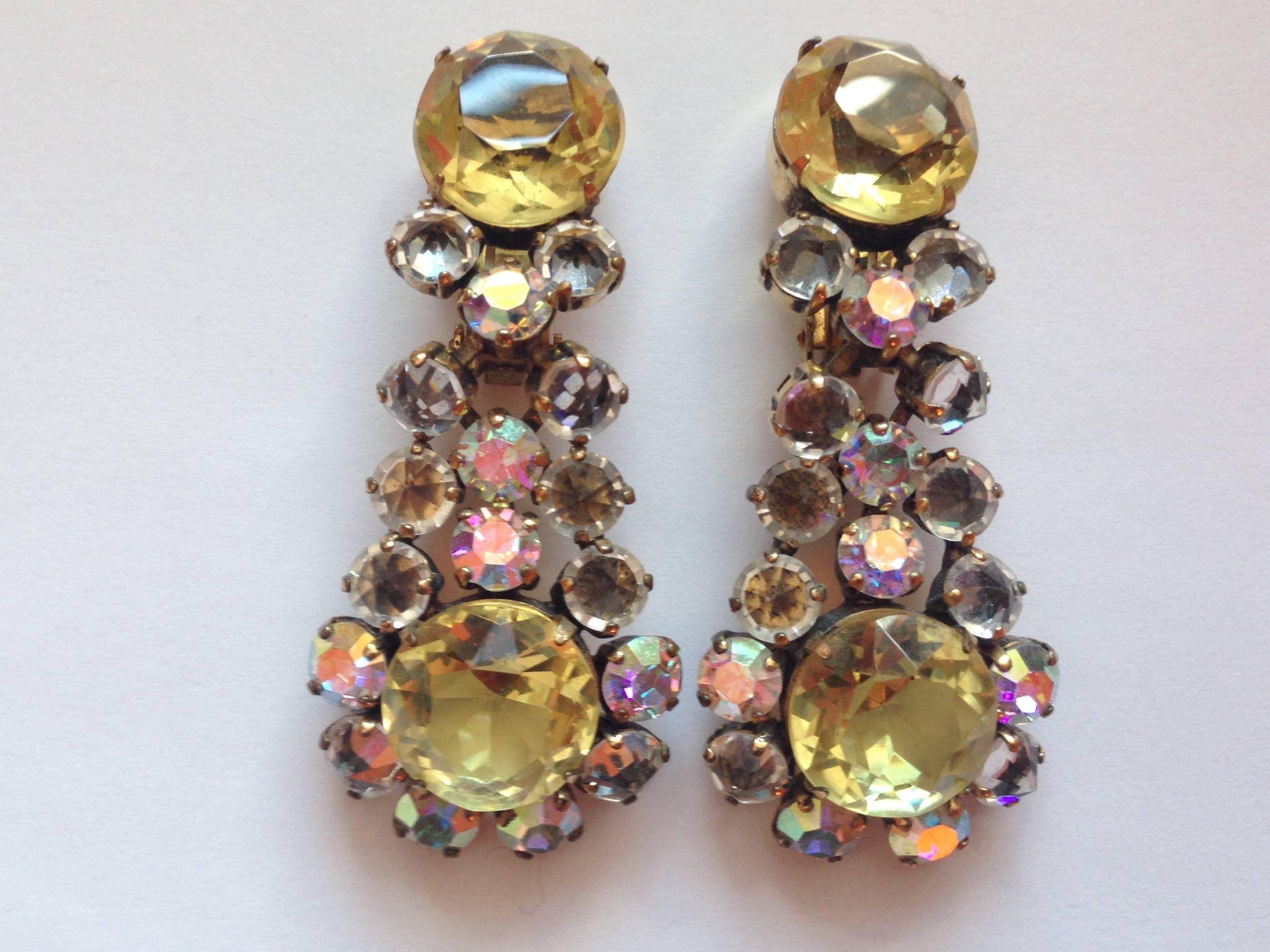 This is a beautiful pair of 1950s Schreiner chandelier clip-on earrings. They are gold toned metal with yellow and clear glass crystals with some stones set with pointed side up - a Schreiner trademark.  They measure 2 3/8" long x 1" wide
