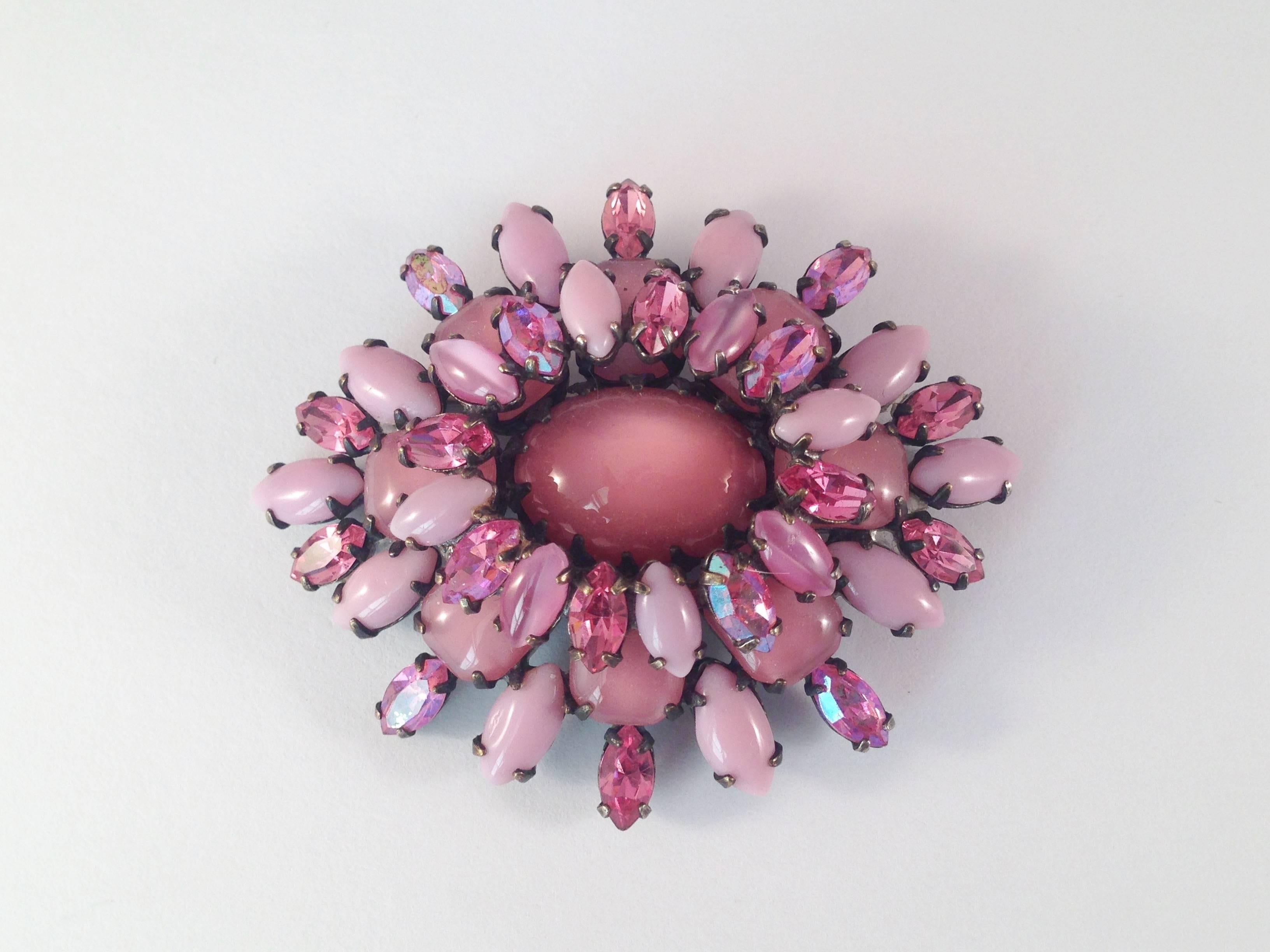 This brooch is a beautiful 1950s pink glass brooch from Schreiner. The colors are gorgeous. It is made up of a mix of pink opaque, clear and rhinestone glass stones. The brooch is in excellent condition. The only flaw to note is that there is some