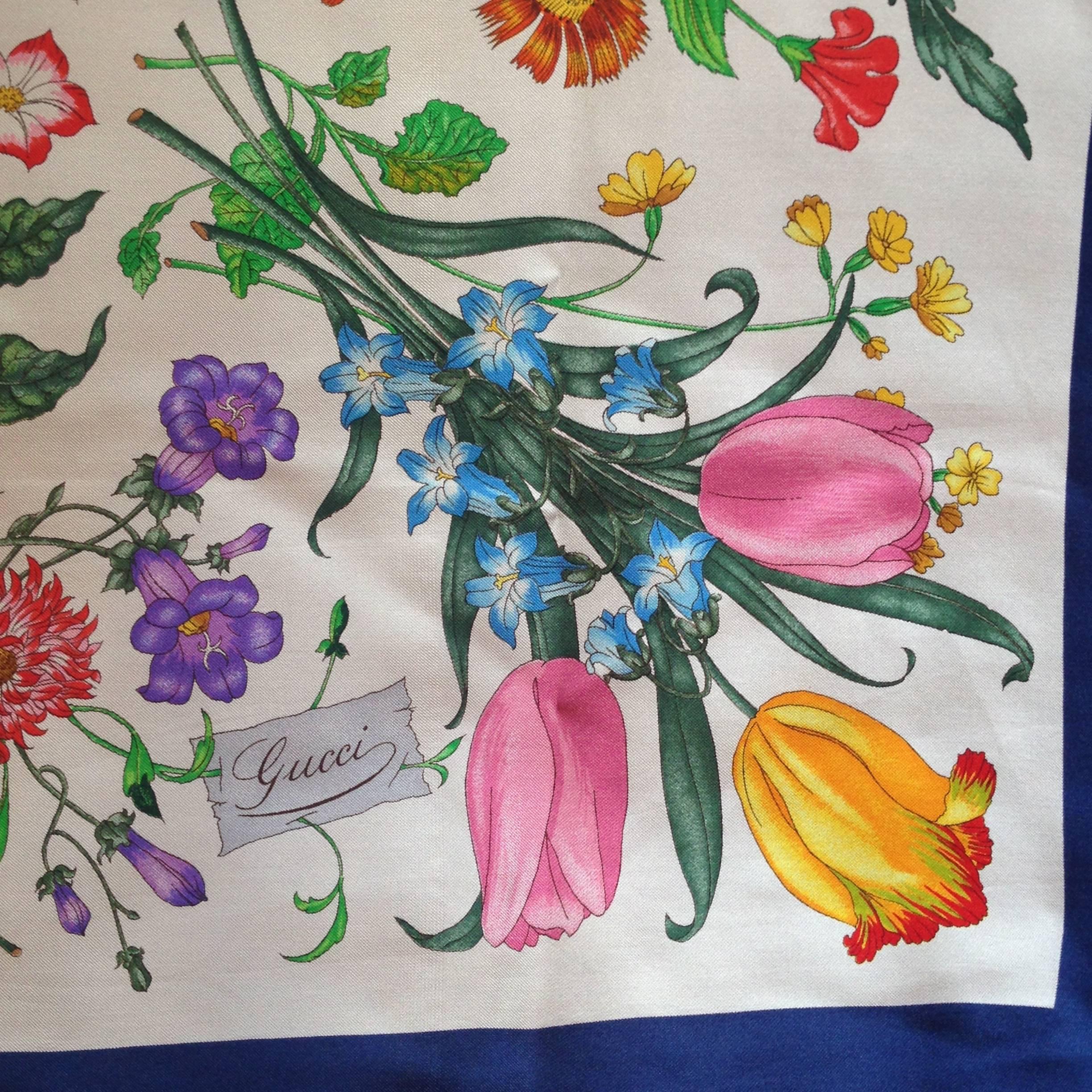 This 1980s signature floral print scarf from Gucci features the iconic 'Flora' pattern with a navy border. It measures 34