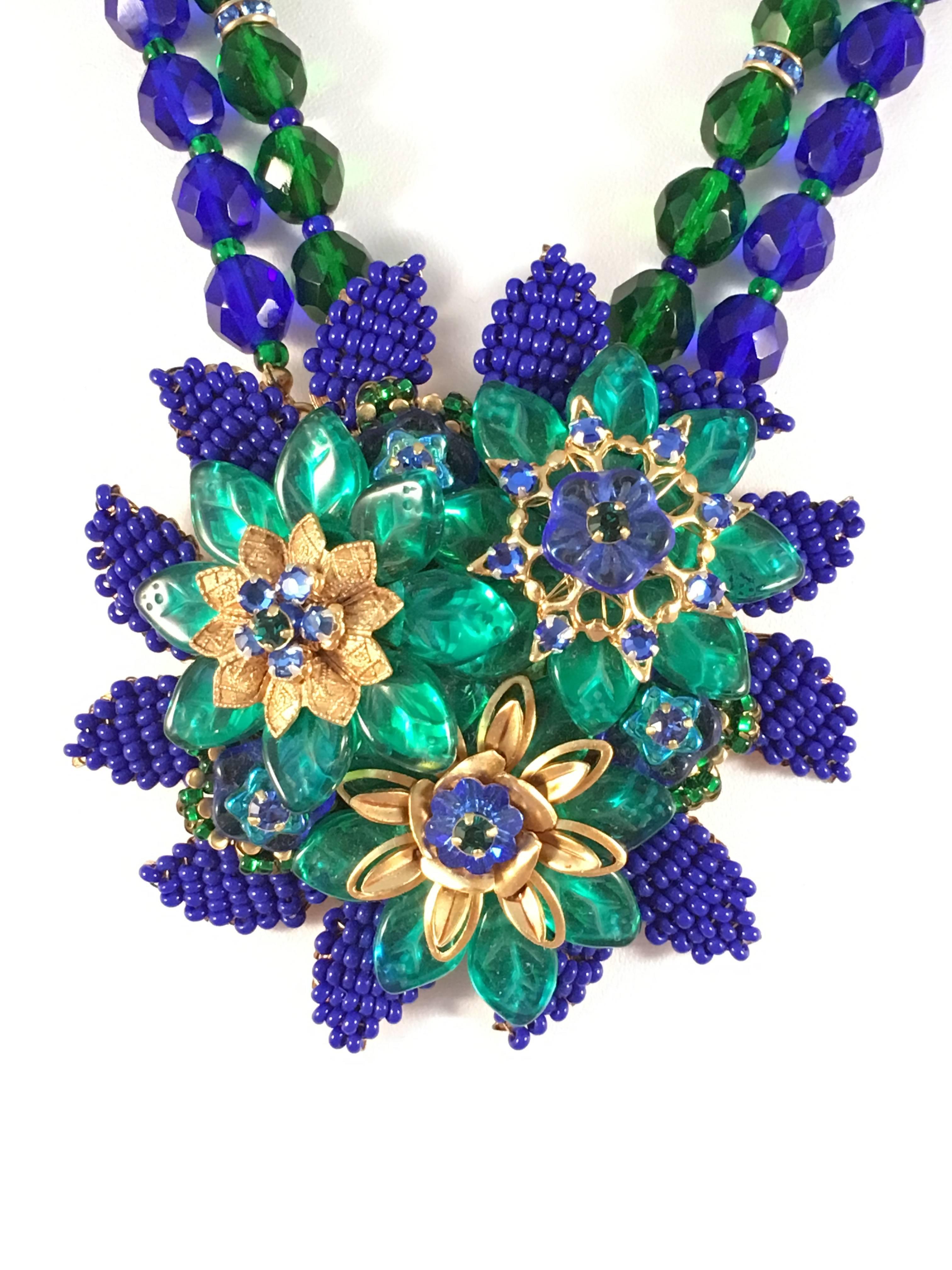 This spectacular necklace is bursting with color and detail. Its pendant is made up of all different glass beads and measures 2 5/8" in diameter. The necklace is adjustable and can be worn as an 18 1/2" necklace up to 21". It is