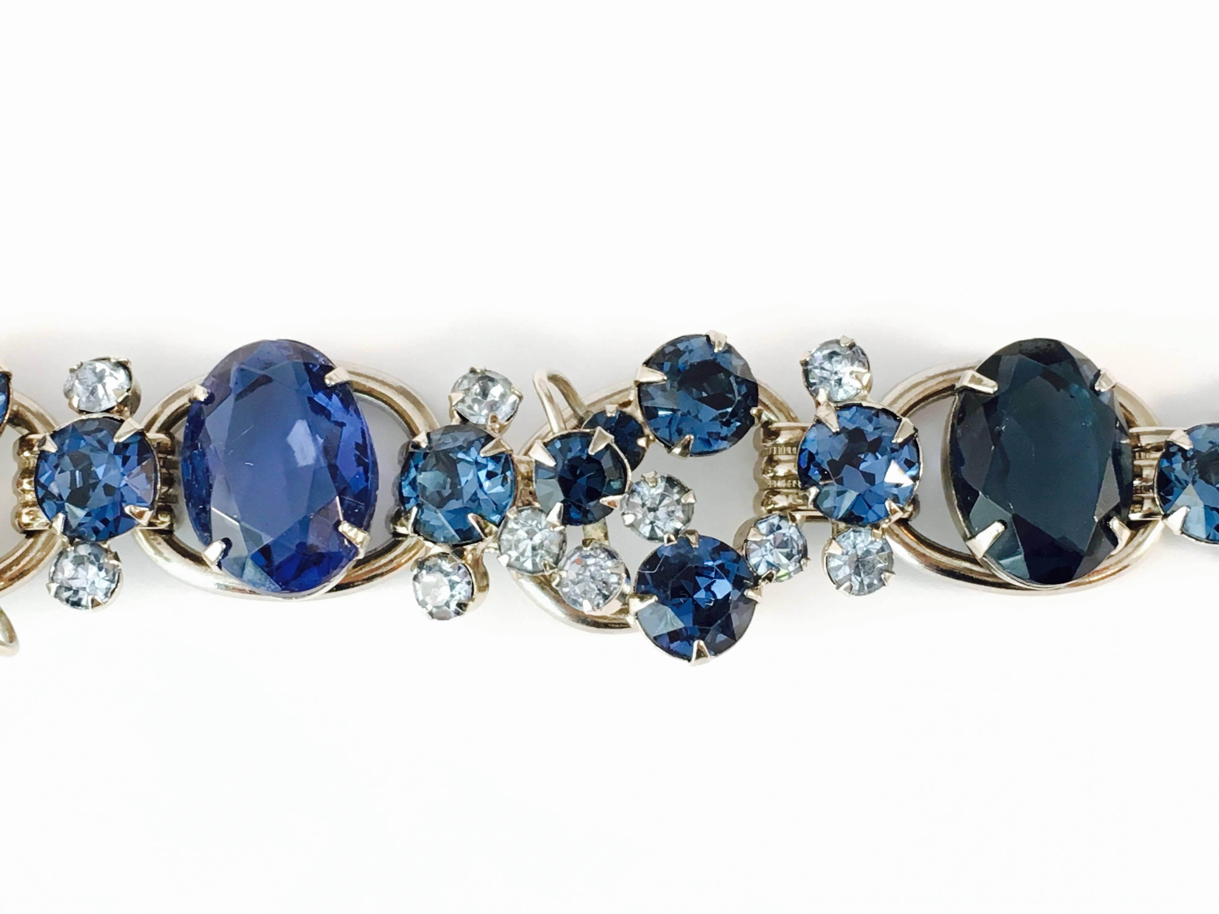 This beautiful silver-tone blue rhinestone Juliana bracelet is made up of brilliant, high quality, light and dark blue crystal glass stones which are prong set. It measures 7 1/4" long and 7/8" wide. It has a fold-over clasp and its