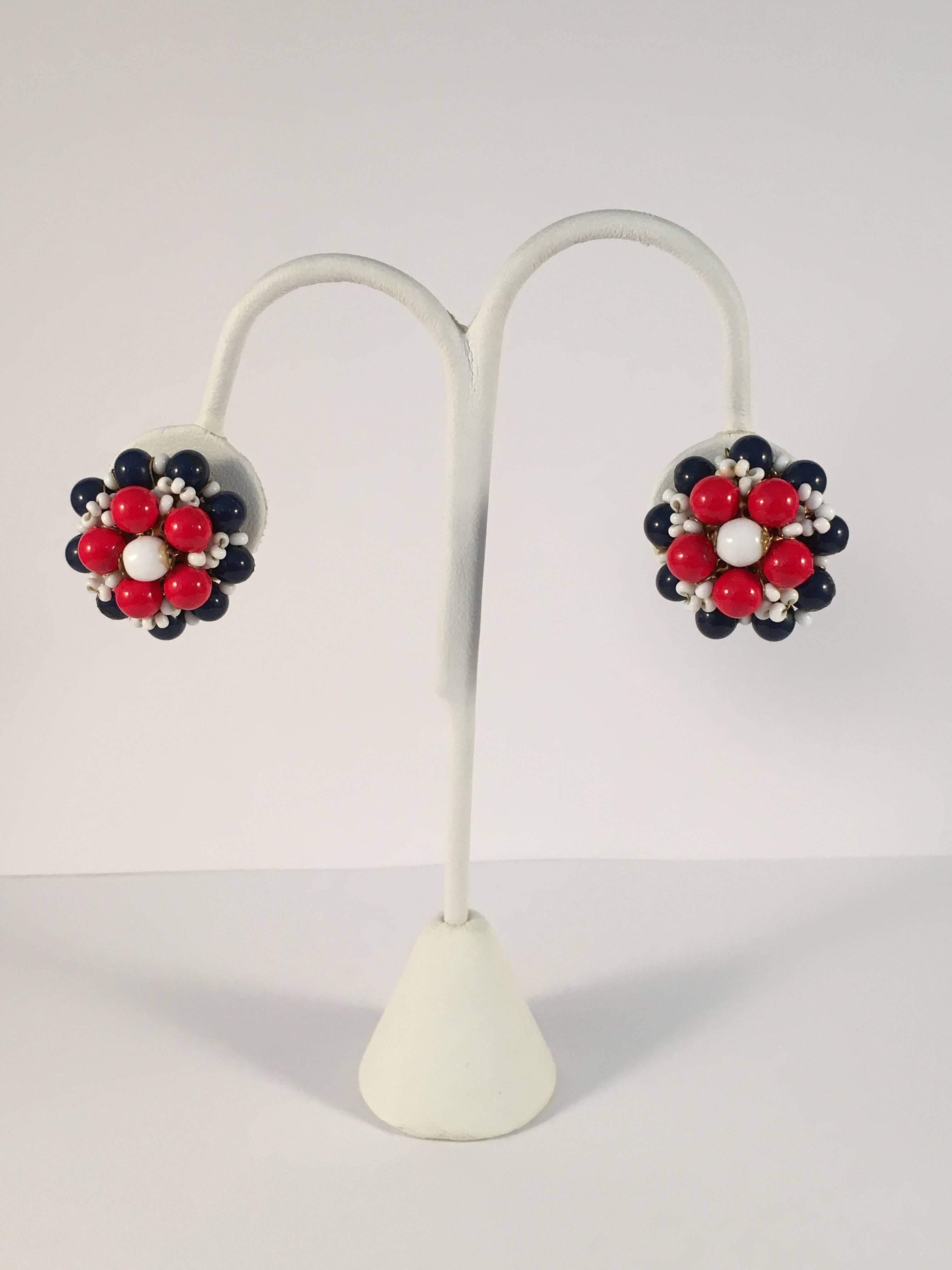Fun MOD 1960s Miriam Haskell red, white and blue beaded clip-on earrings. Classic filigree backs with brass wired elements. The earrings measure 1" in diameter. They are clip earrings and have a clip-screw hardware mechanism that make for
