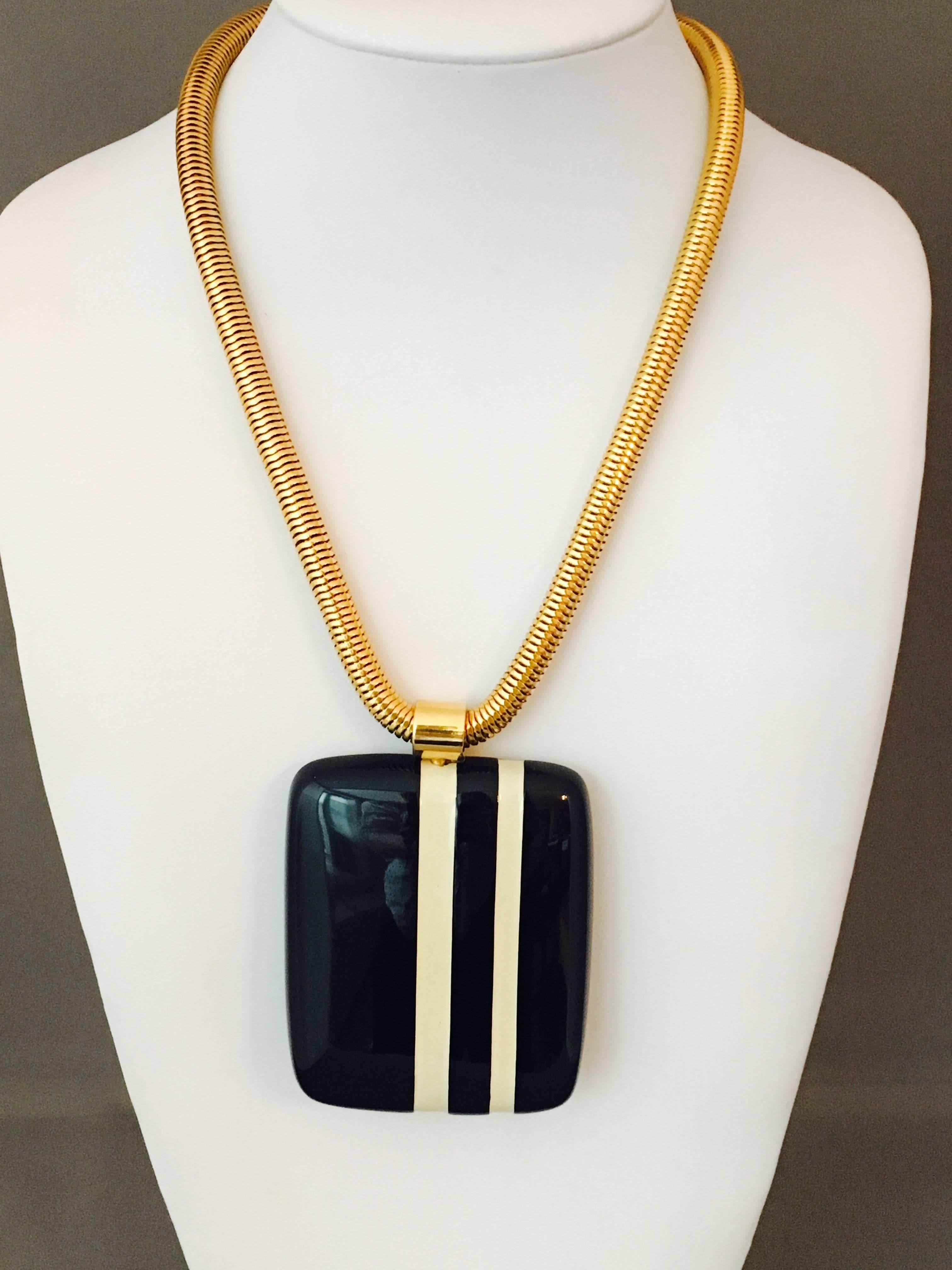 This is an amazing 1970s navy blue and white striped Lanvin necklace and clip-on earring set. It consists of a large, heavy, resin pendant on a gold-tone snake chain and matching earrings. The  pendant measures 3