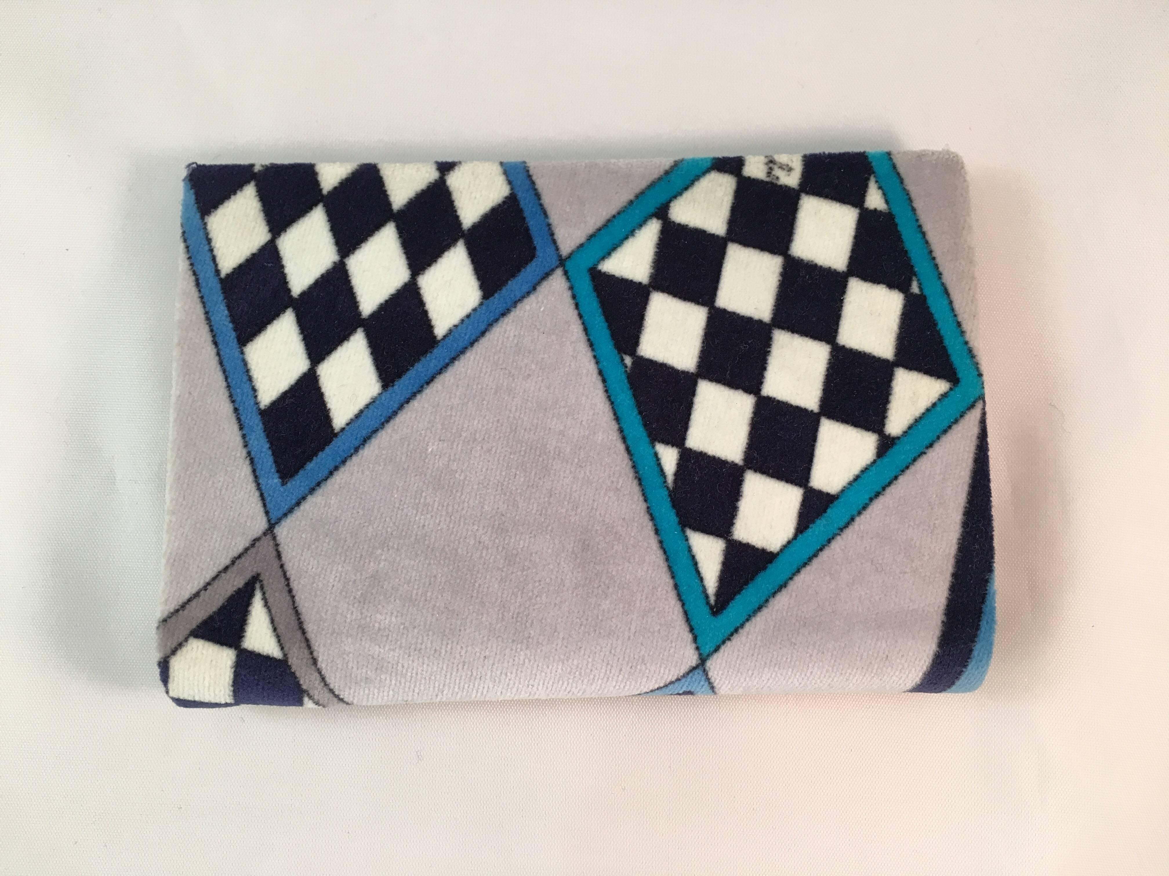 This is a 1960s printed velvet and leather Emilio Pucci wallet. It is in excellent condition and looks as if it was never used. It features a geometric print in black and white and shades of grey and blue. the interior is a teal colored leather. It